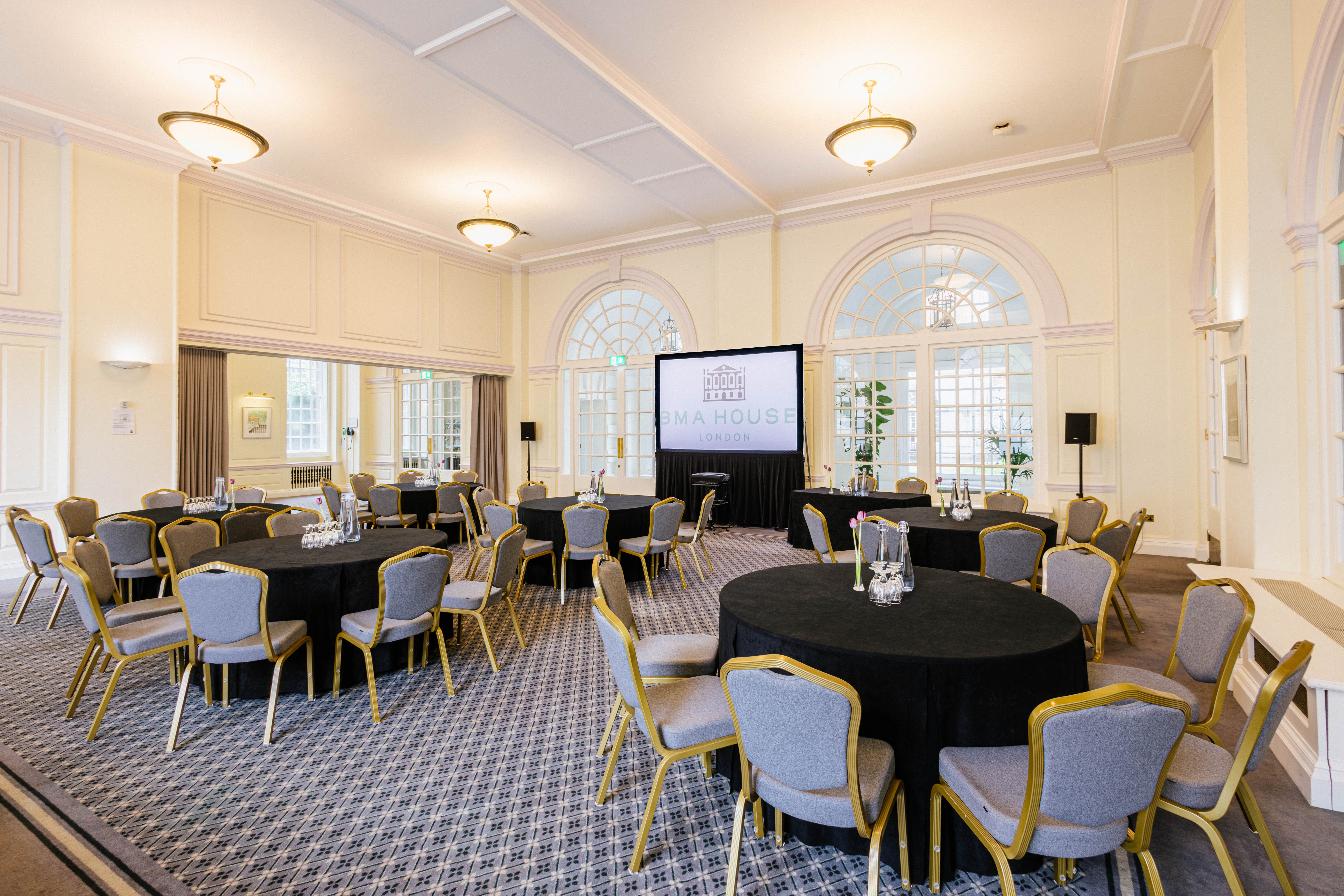 Snow Room at BMA House: elegant event space with round tables, ideal for meetings and gatherings.