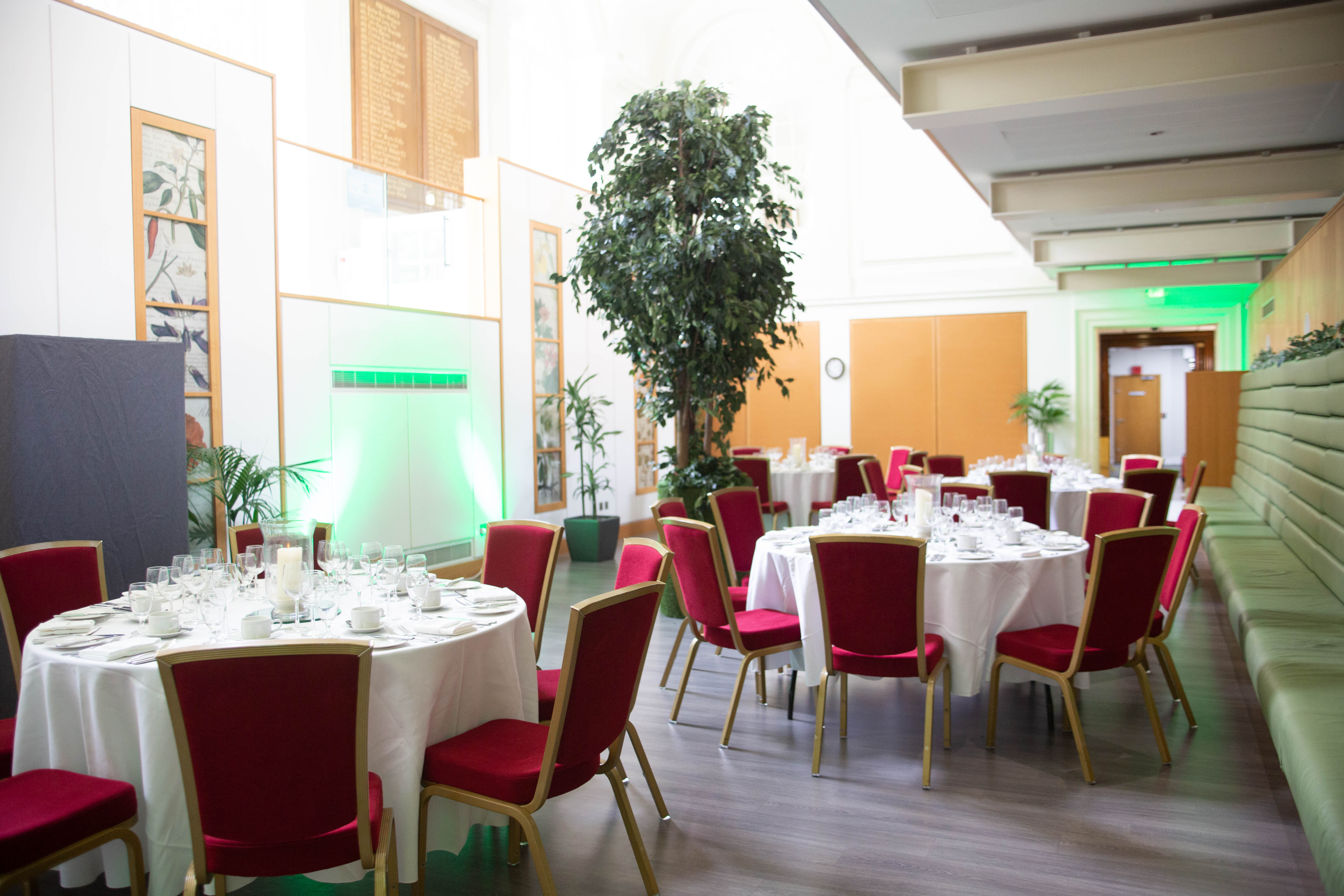 Elegant Garden Room event space with round tables, perfect for meetings and celebrations.