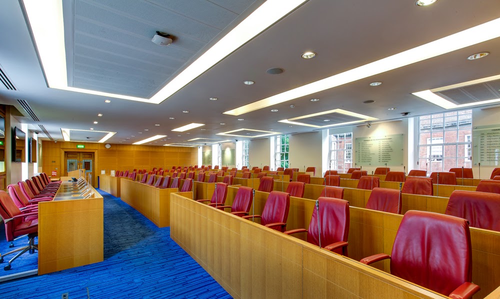Modern conference room with tiered red leather seating for events and presentations.
