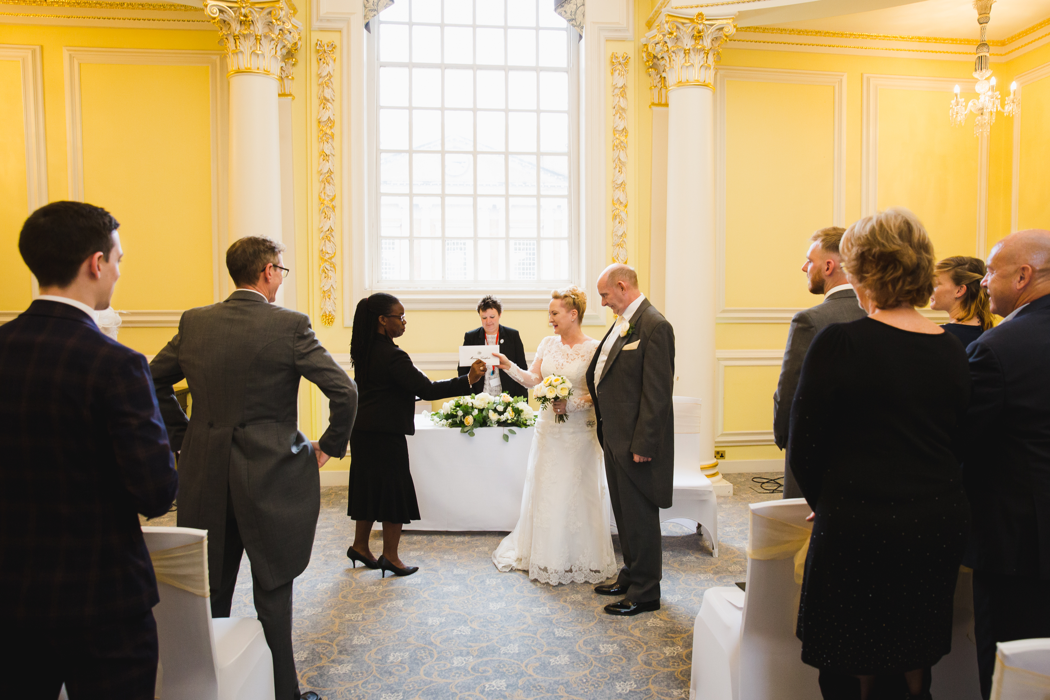 Elegant wedding ceremony in Prince's Room, BMA House with warm yellow decor.