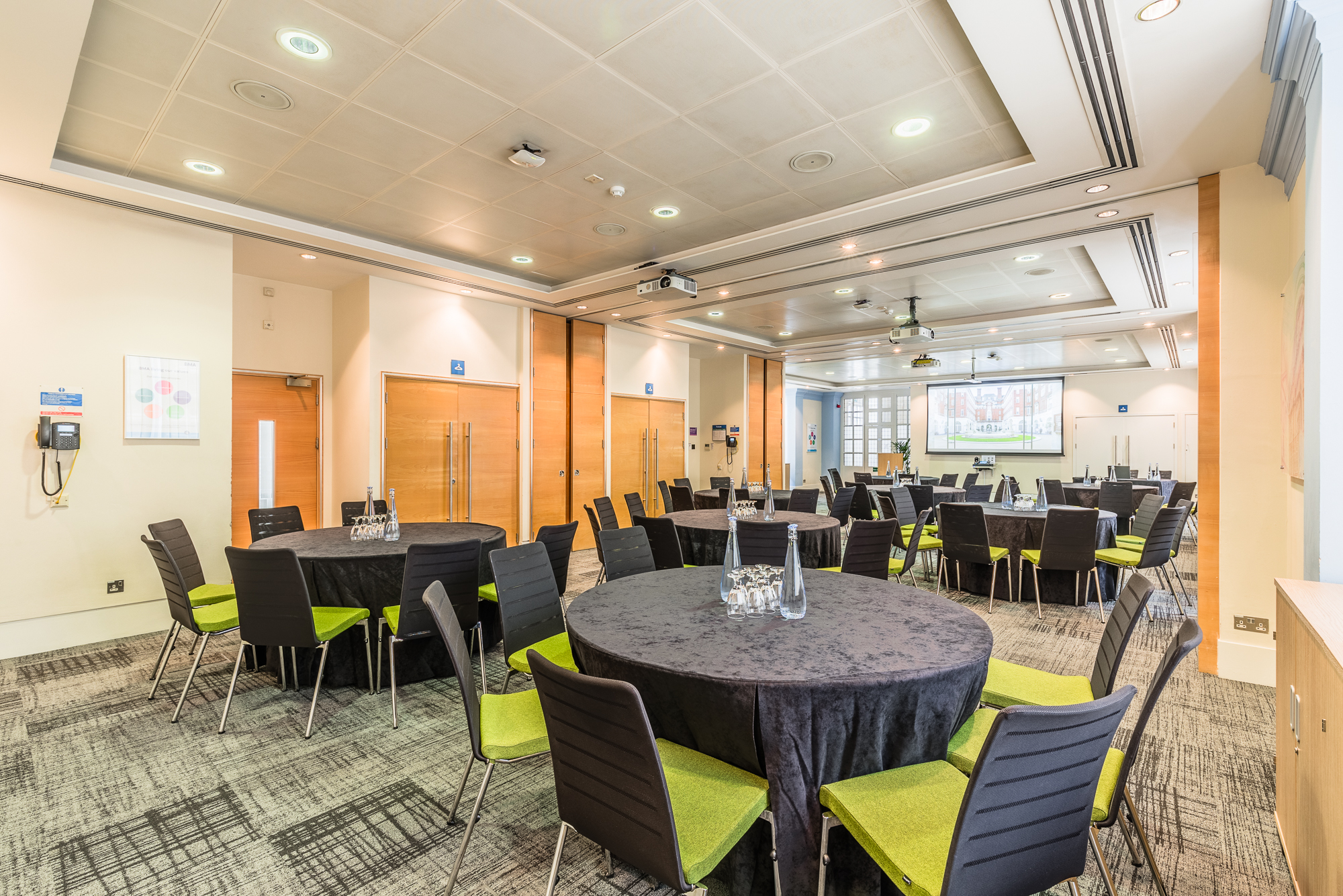 Courtyard Suite at BMA House, modern meeting space with round tables for events.