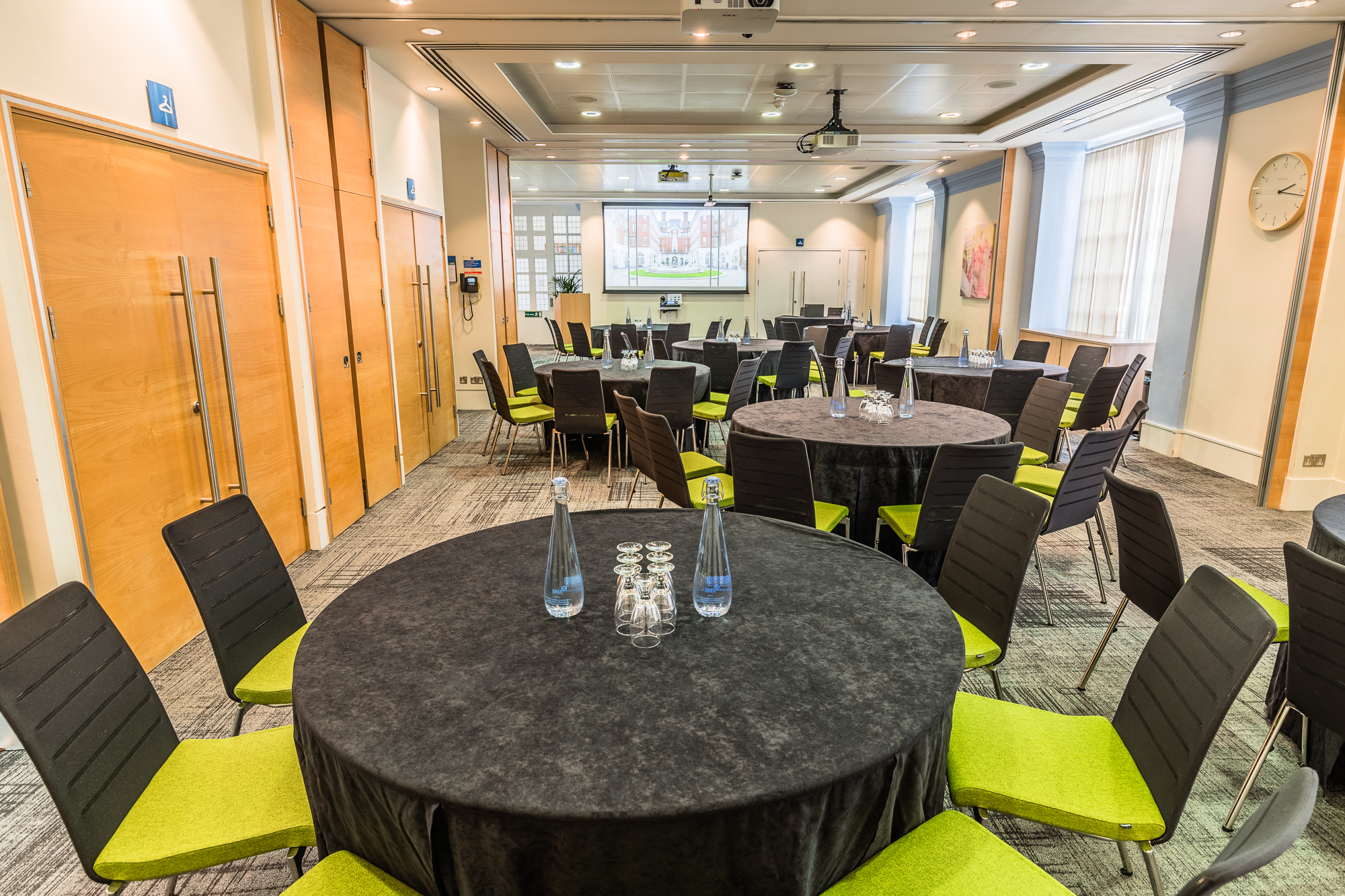 Courtyard Suite at BMA House: modern meeting space with projector, ideal for events.