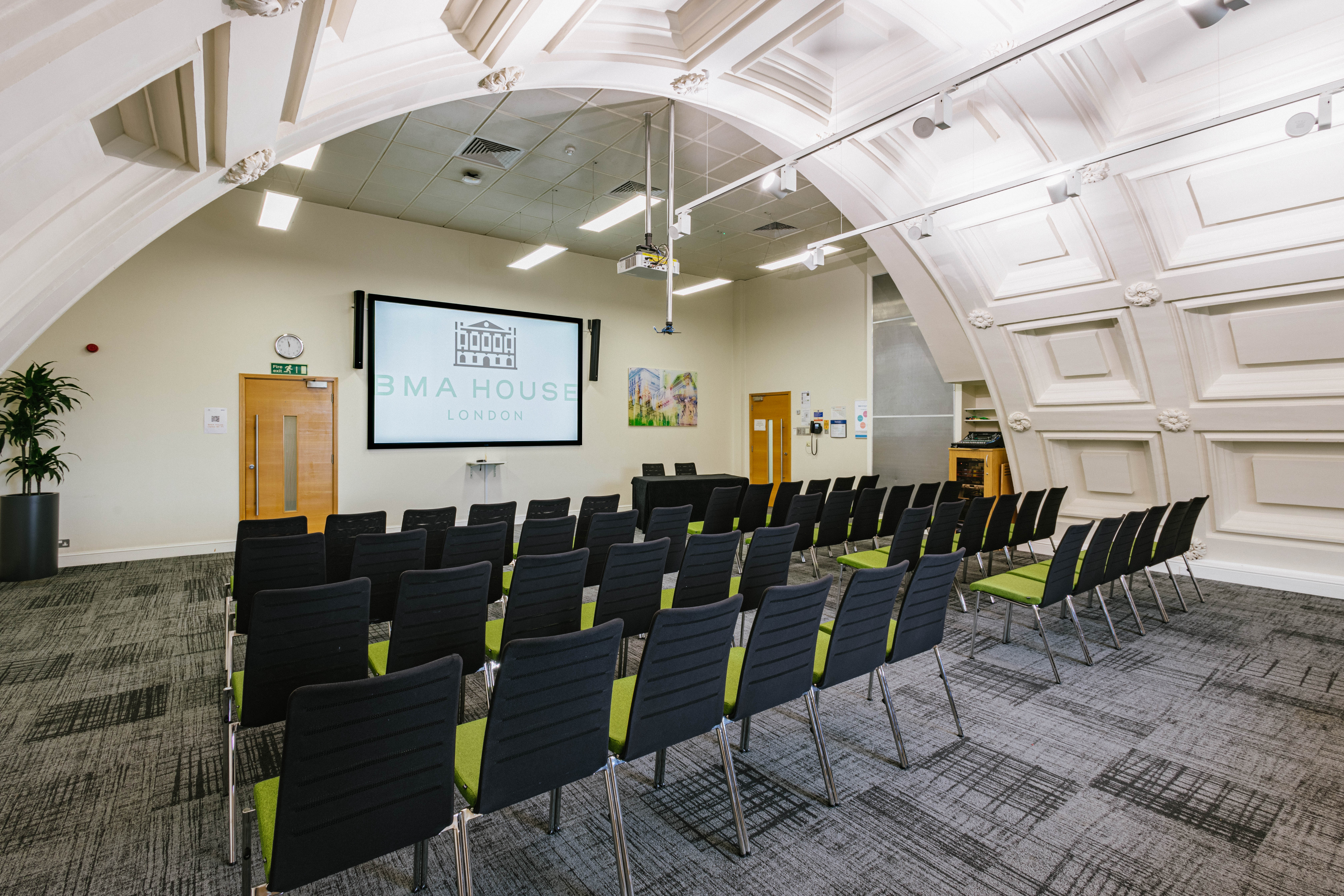 Harvey room at BMA House: modern meeting space with black and green chairs, ideal for conferences.