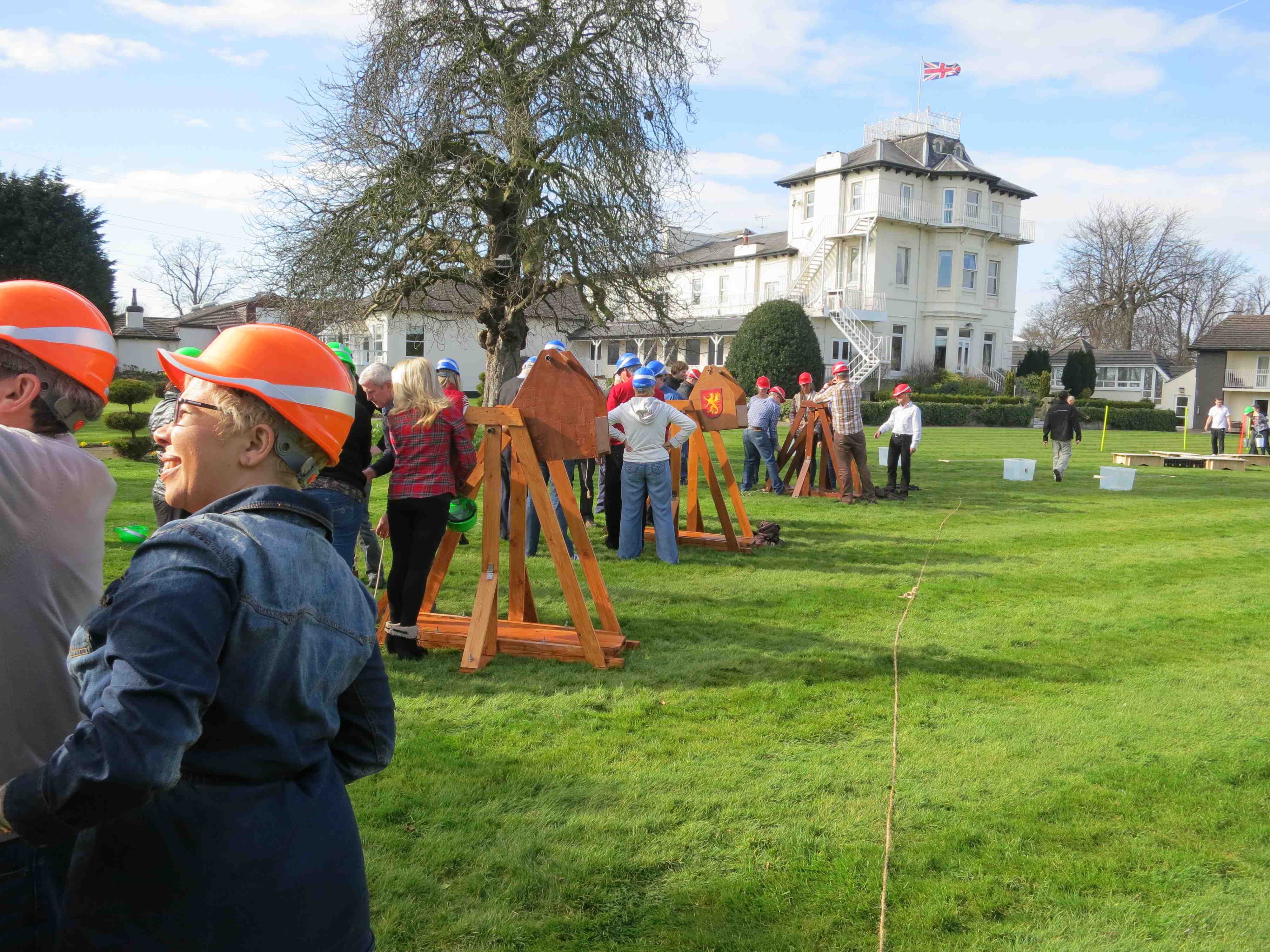 Team-building event at Torintone Suite, participants in safety helmets outdoors.