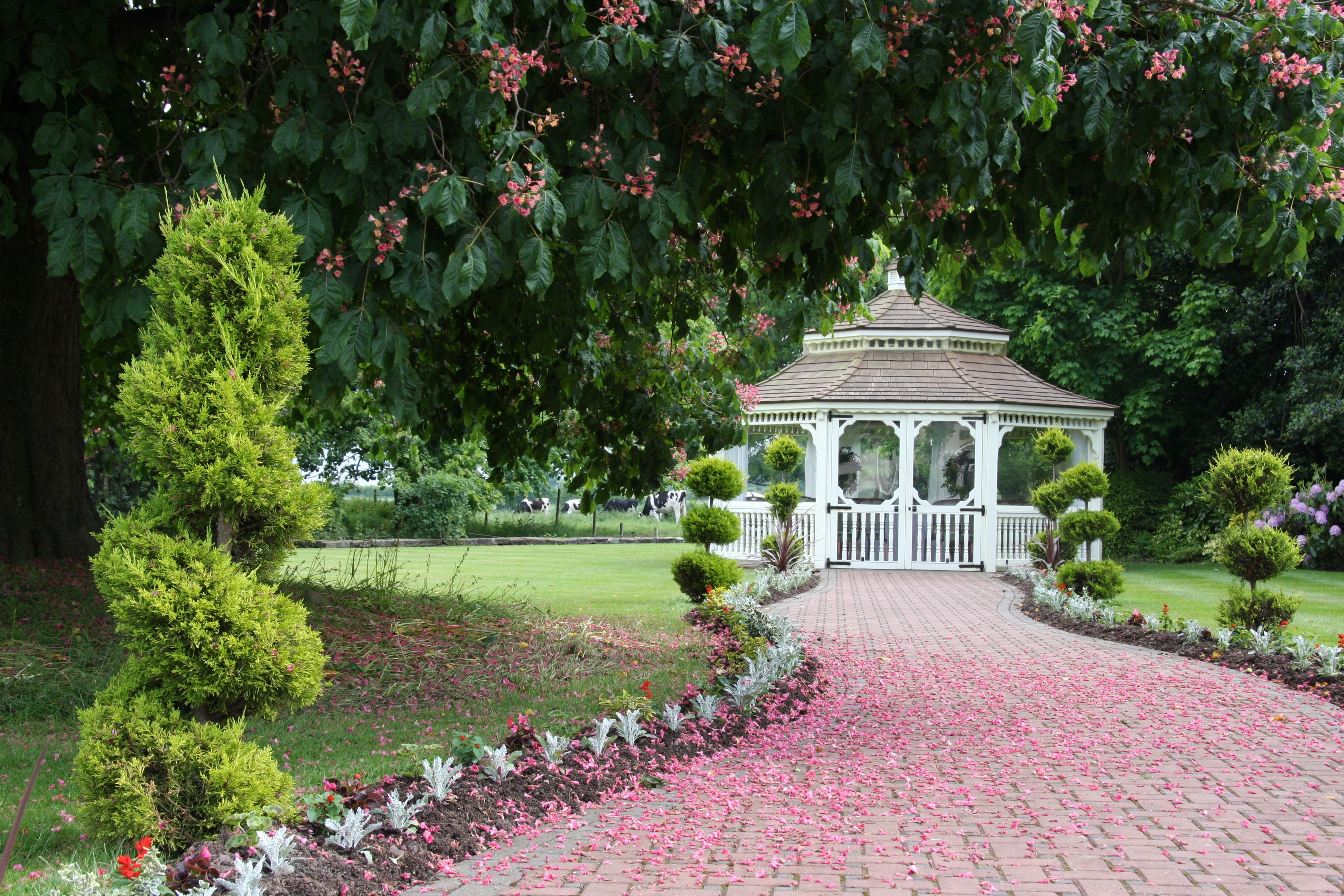 Pulford Suite gazebo in lush garden, perfect for weddings and outdoor events.
