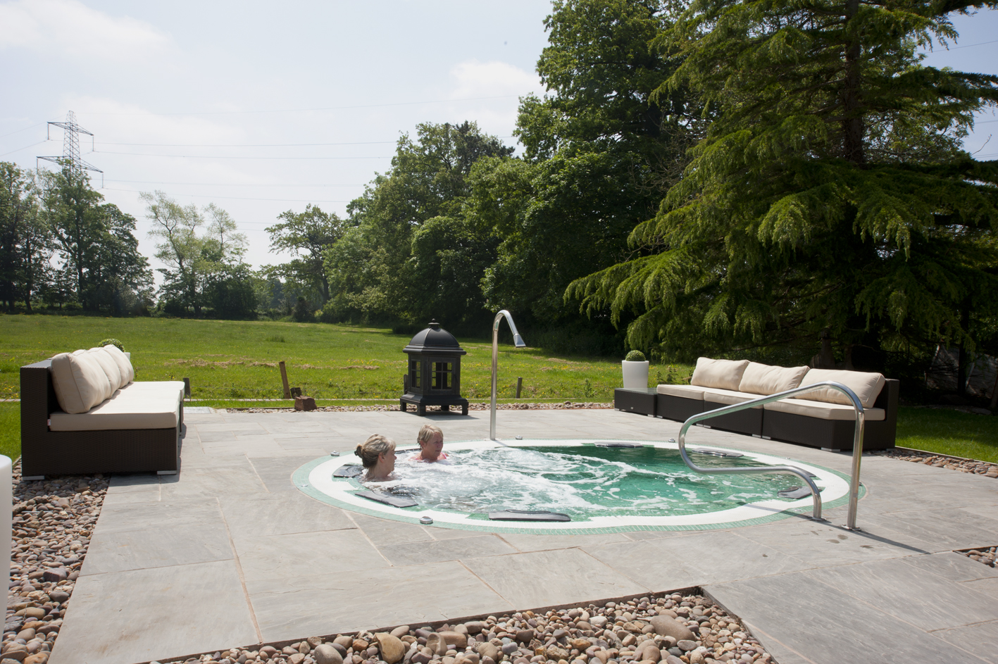 Pulford Suite hot tub in lush greenery, ideal for retreats and team-building events.