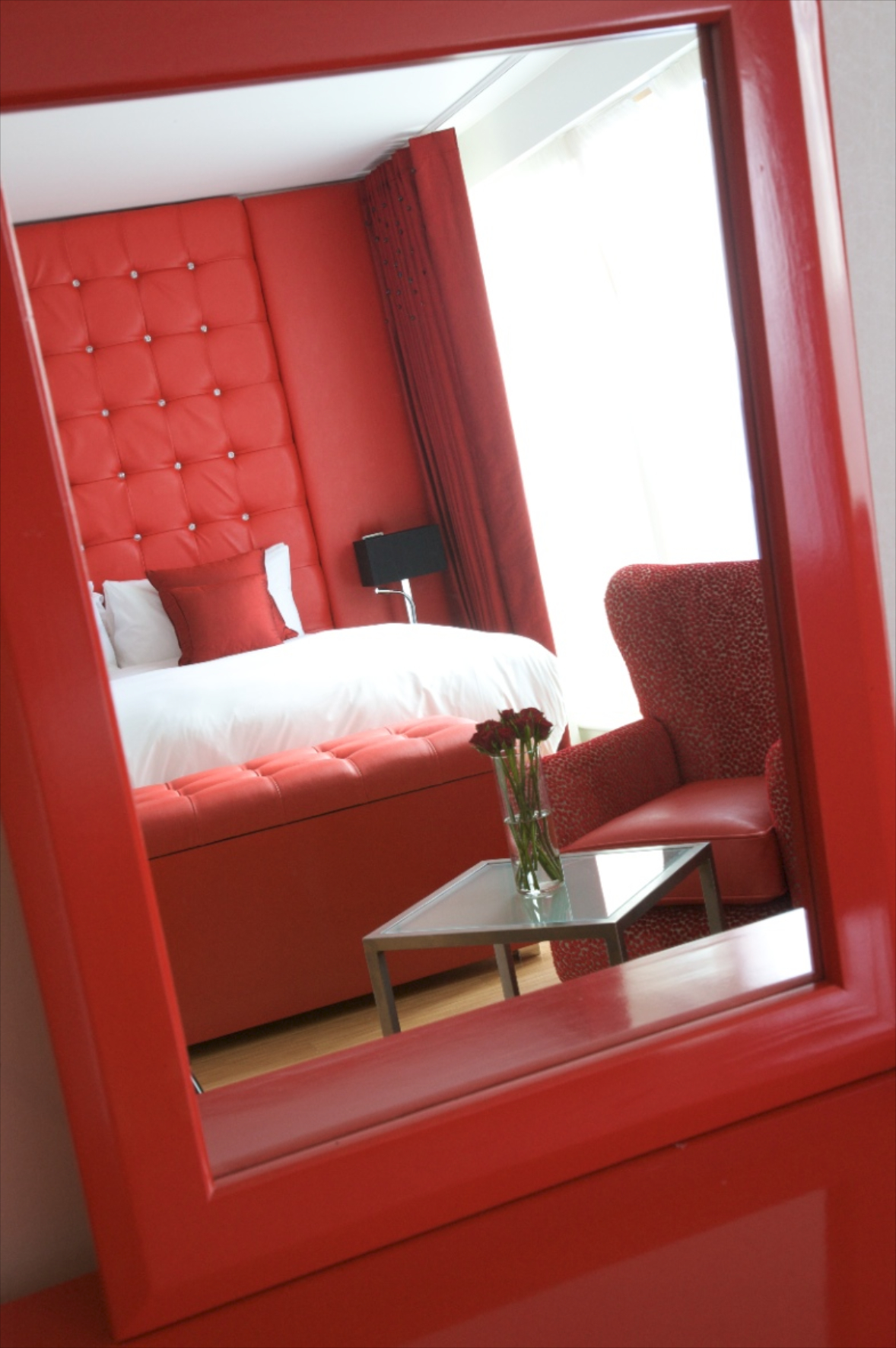 Ruby Loft Suite at Bermondsey Square Hotel, vibrant red accents, ideal for retreats and gatherings.