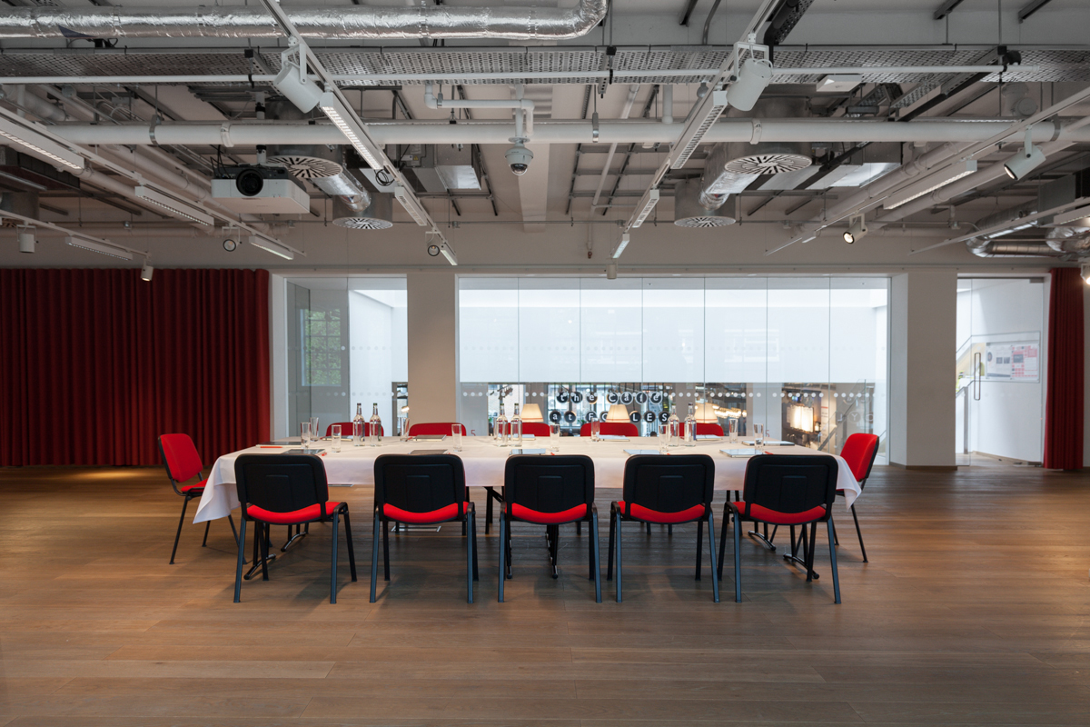 Modern auditorium meeting space with long table, ideal for events and collaboration.