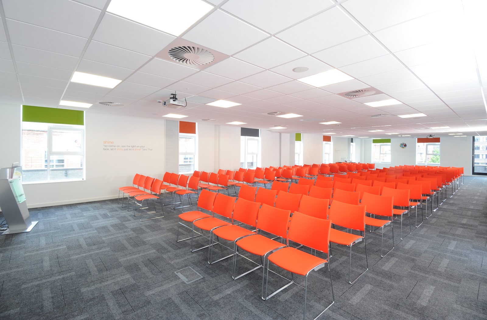 Modern event space in Manchester with vibrant orange chairs for seminars and workshops.