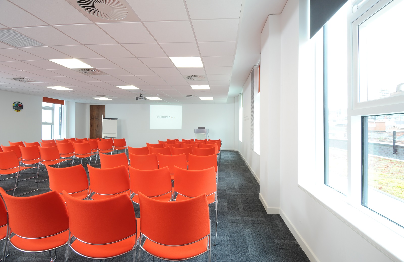 Modern meeting space in thestudio Manchester with vibrant orange chairs for workshops.