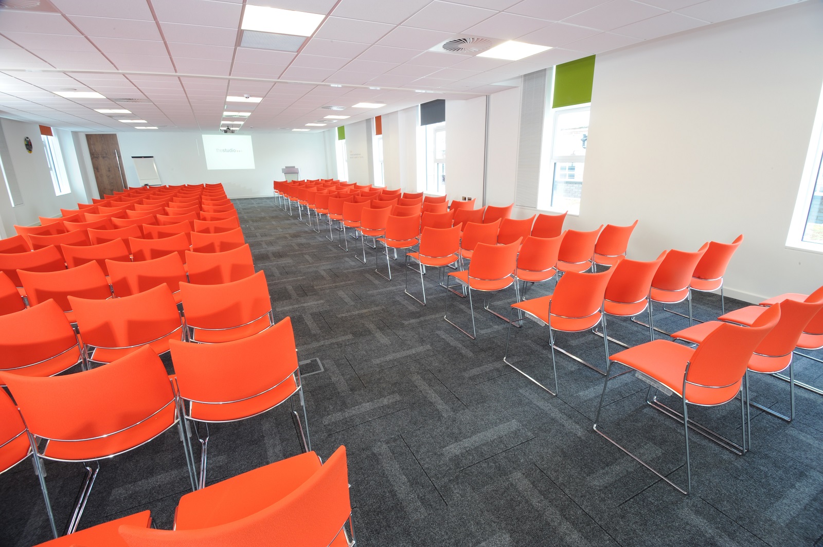 Vibrant orange chairs in a bright meeting space for engaging workshops in Manchester.