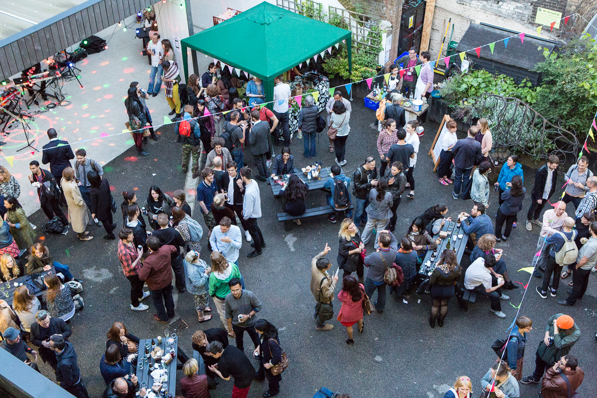 Vibrant outdoor networking event at Bow Arts Courtyard with colorful decorations.