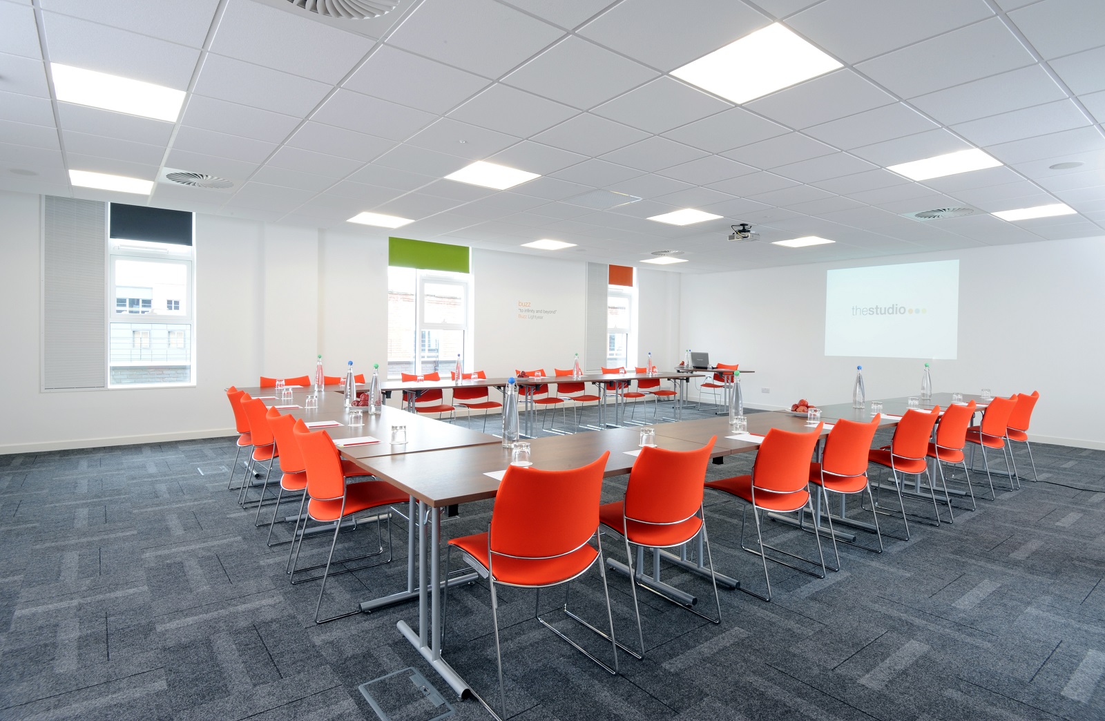 Modern meeting room in Manchester with orange chairs, ideal for workshops and corporate events.