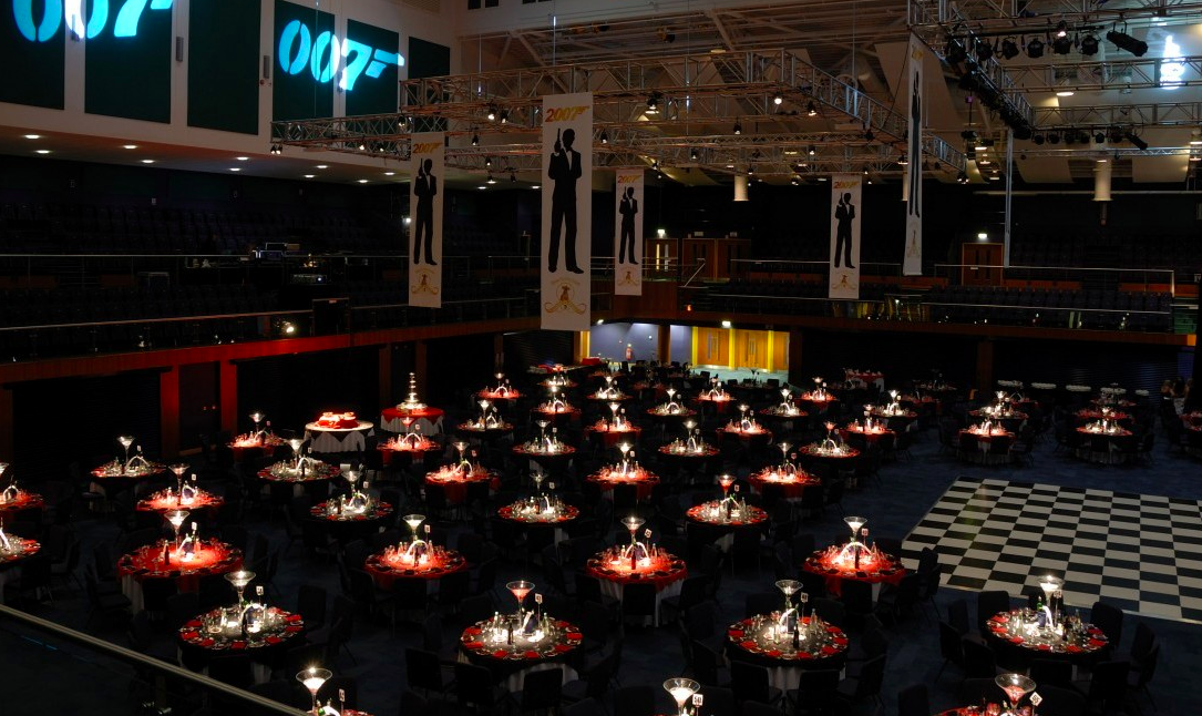 Elegant gala setup at Cheltenham Racecourse with red accents and dramatic lighting.