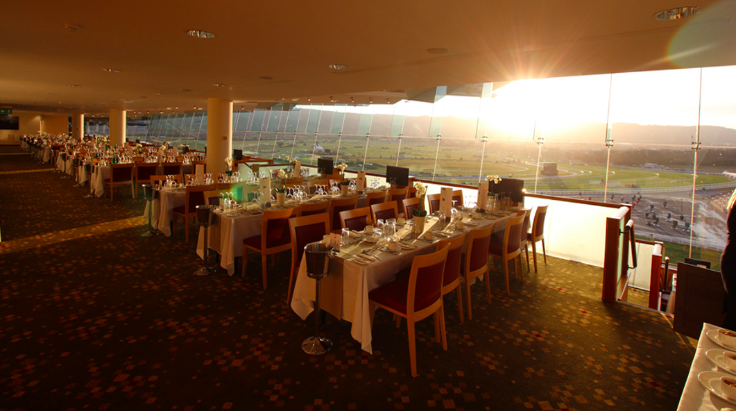 Elegant dining area at Cheltenham Racecourse with panoramic windows for upscale events.
