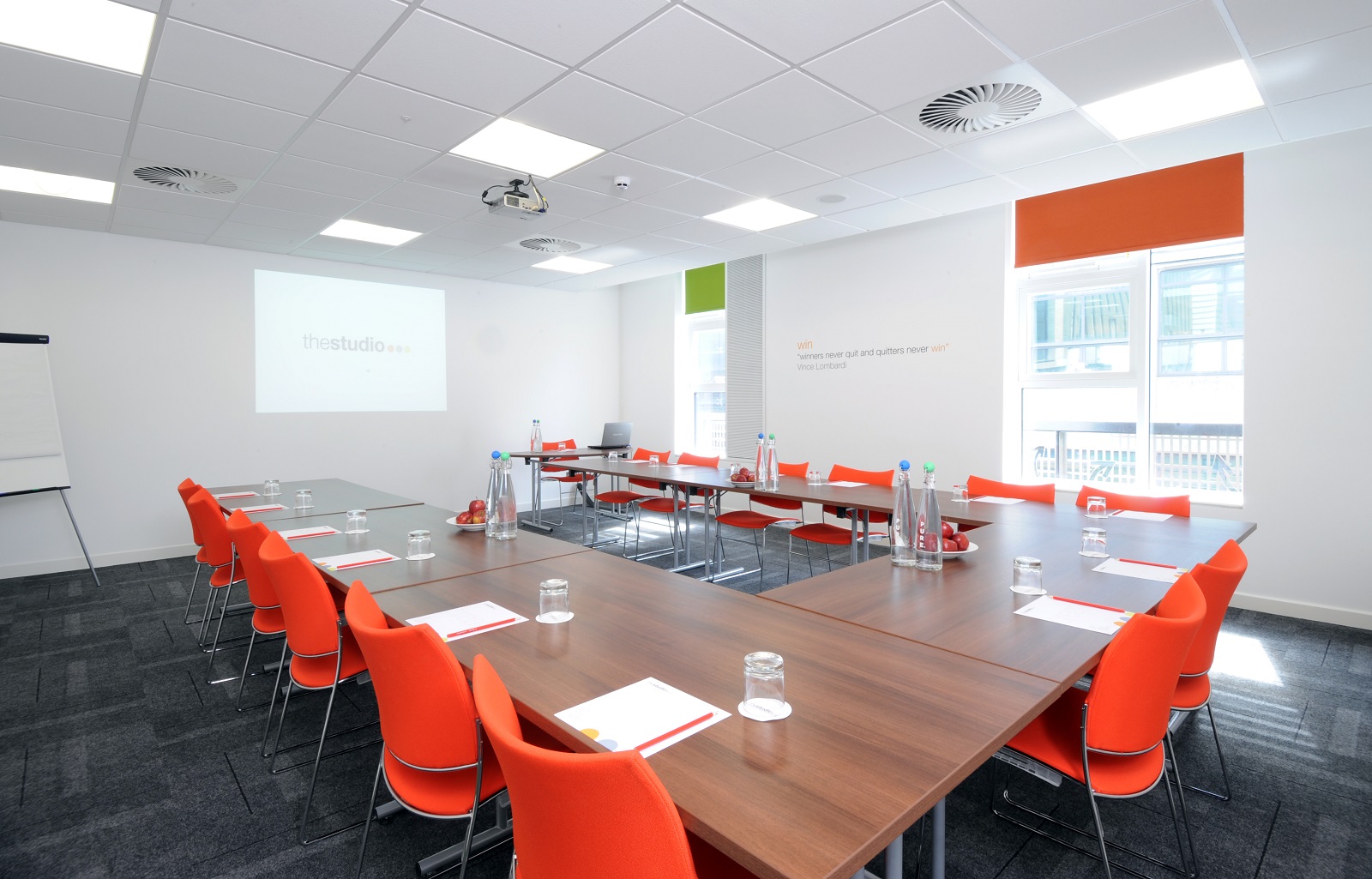 Modern meeting room in Manchester with orange chairs for professional events.