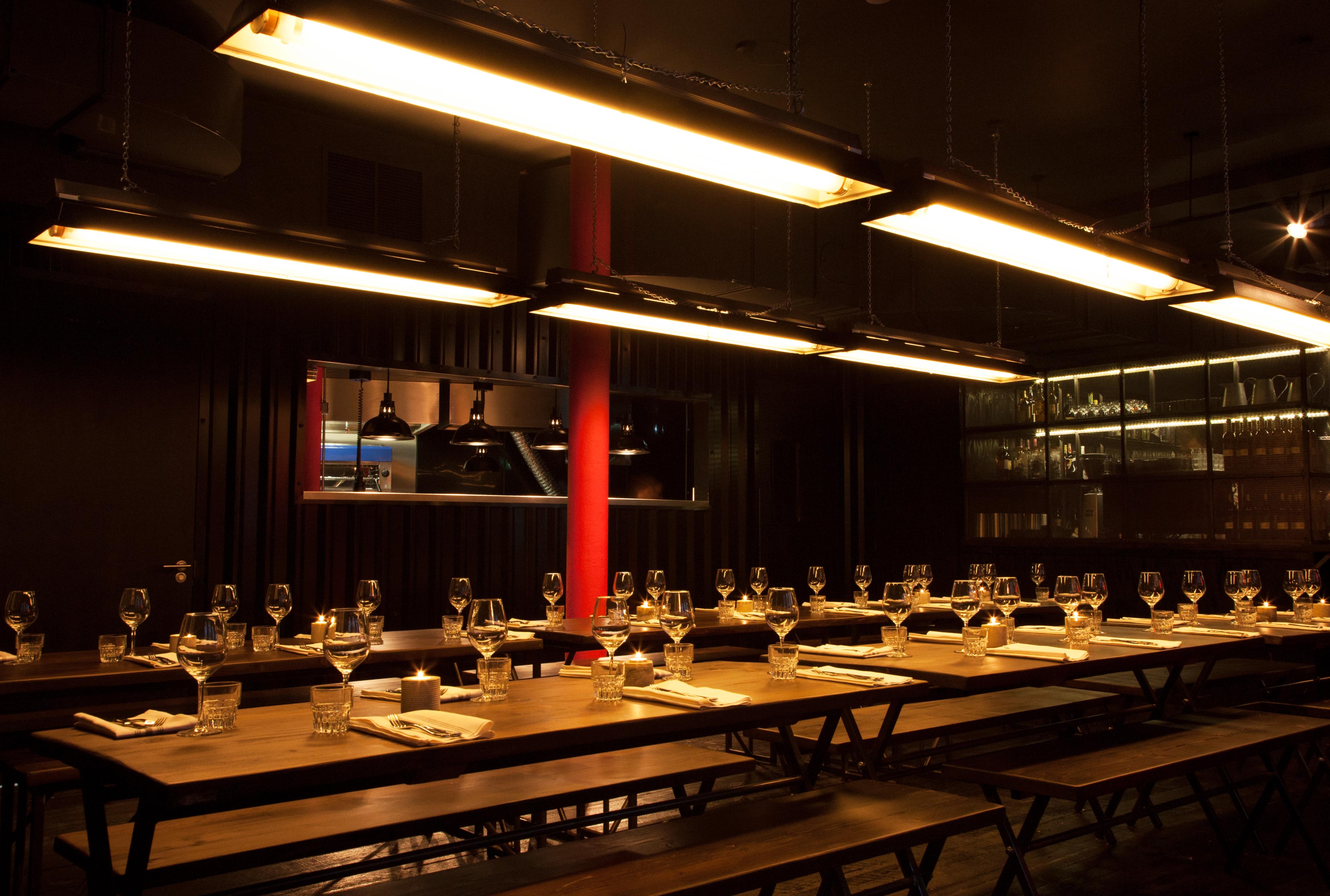 Modern dining space at HotBox London with communal tables for events and warm lighting.