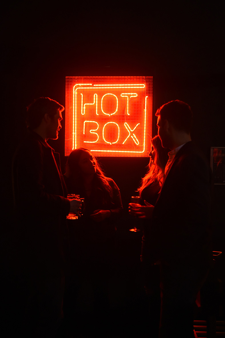 Vibrant networking scene at HotBox Spitalfields with neon sign, ideal for social events.