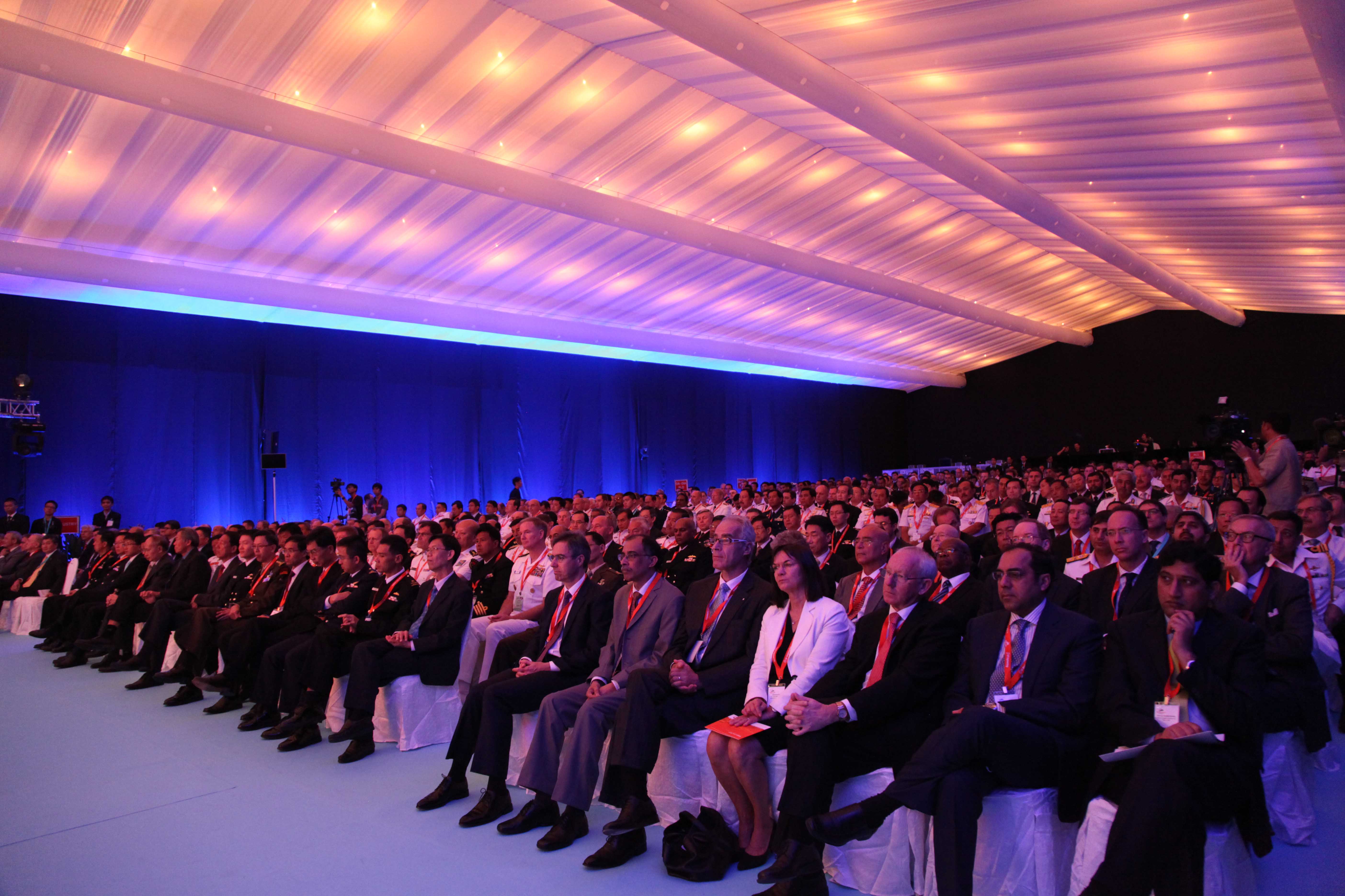 "Changi Exhibition Centre event hall with large audience in formal attire, showcasing effective staging."