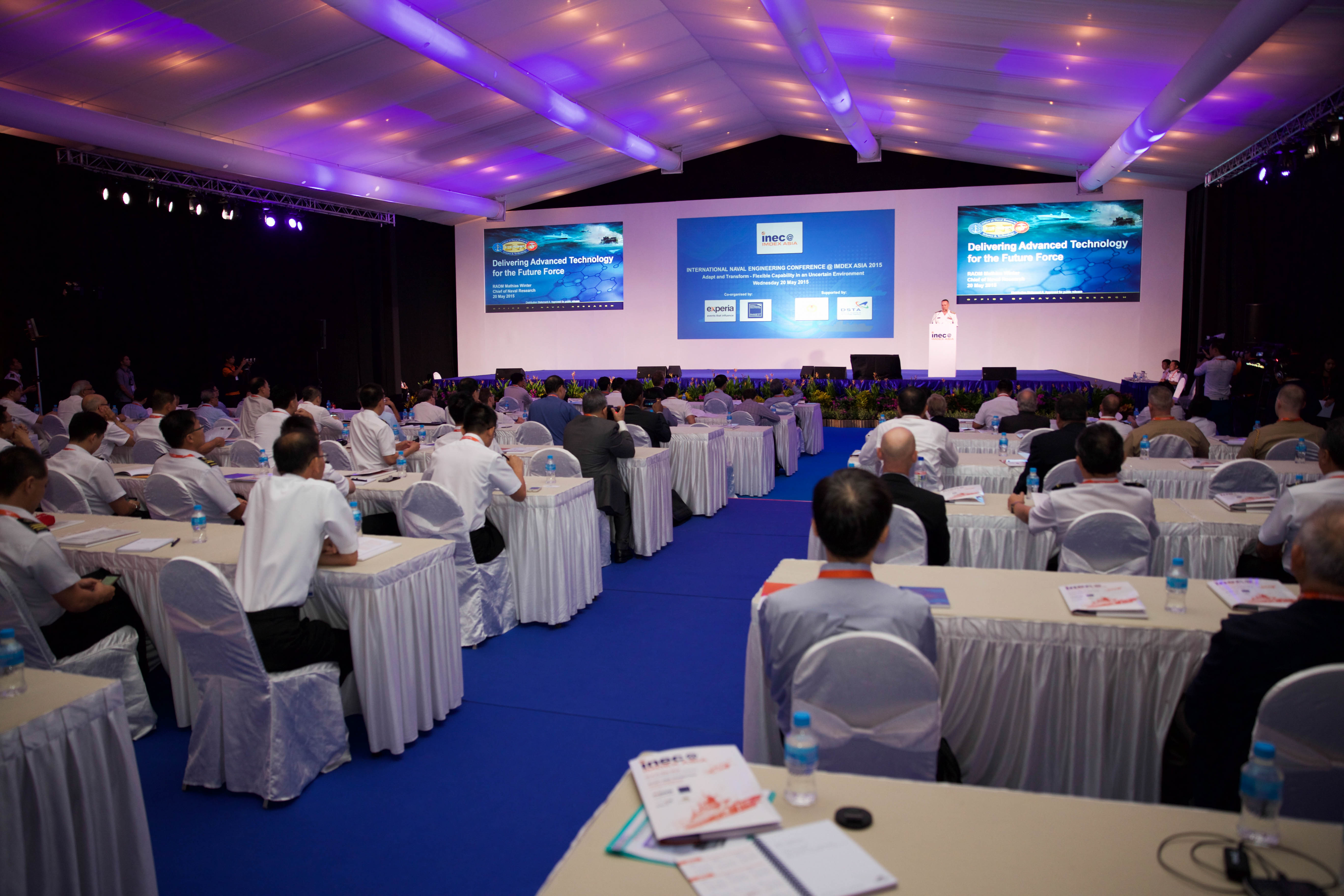 Changi Exhibition Centre auditorium with organized conference setup and branding screens.