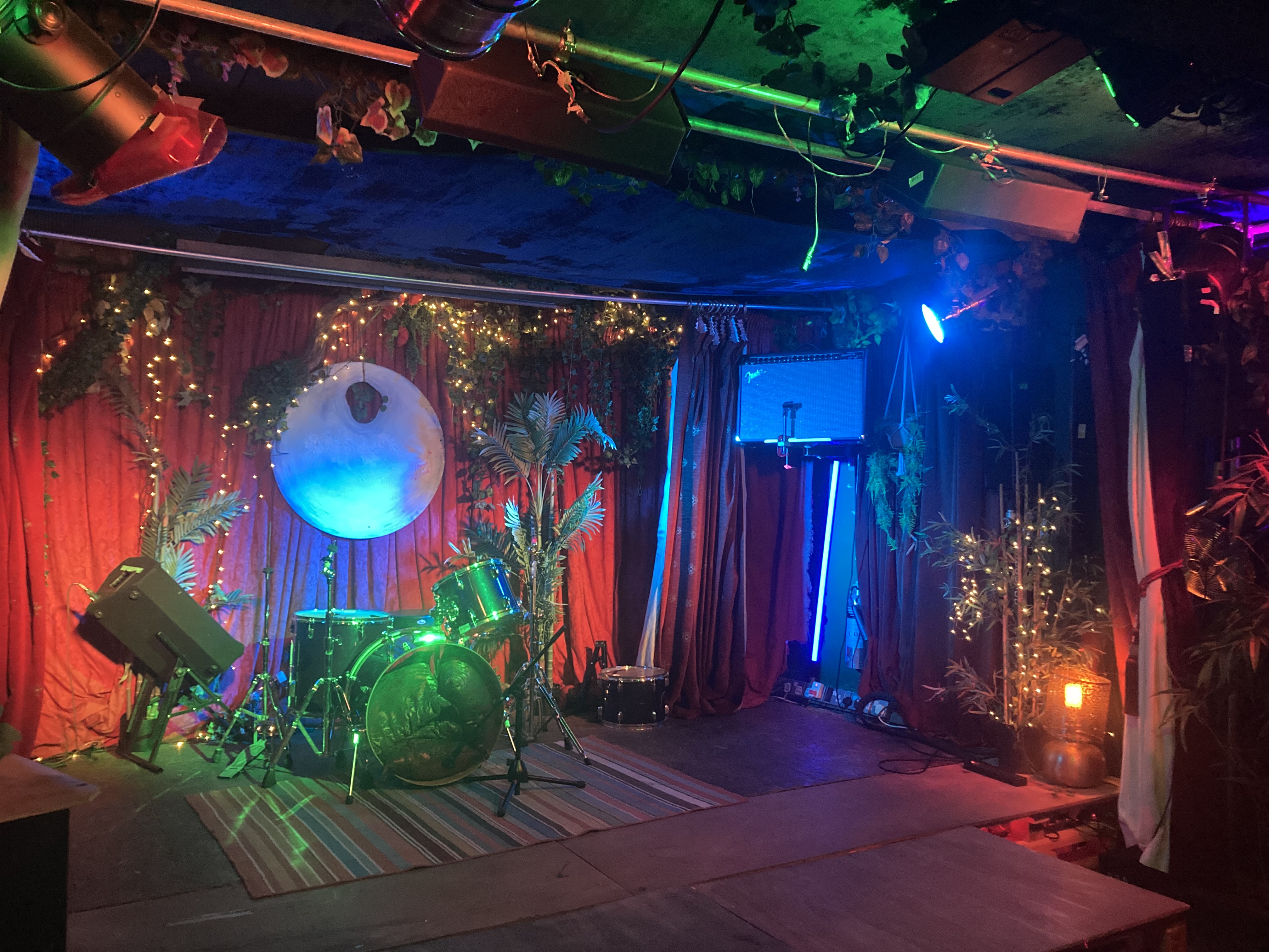 Vibrant event space with lush greenery, ideal for live music performances and parties.