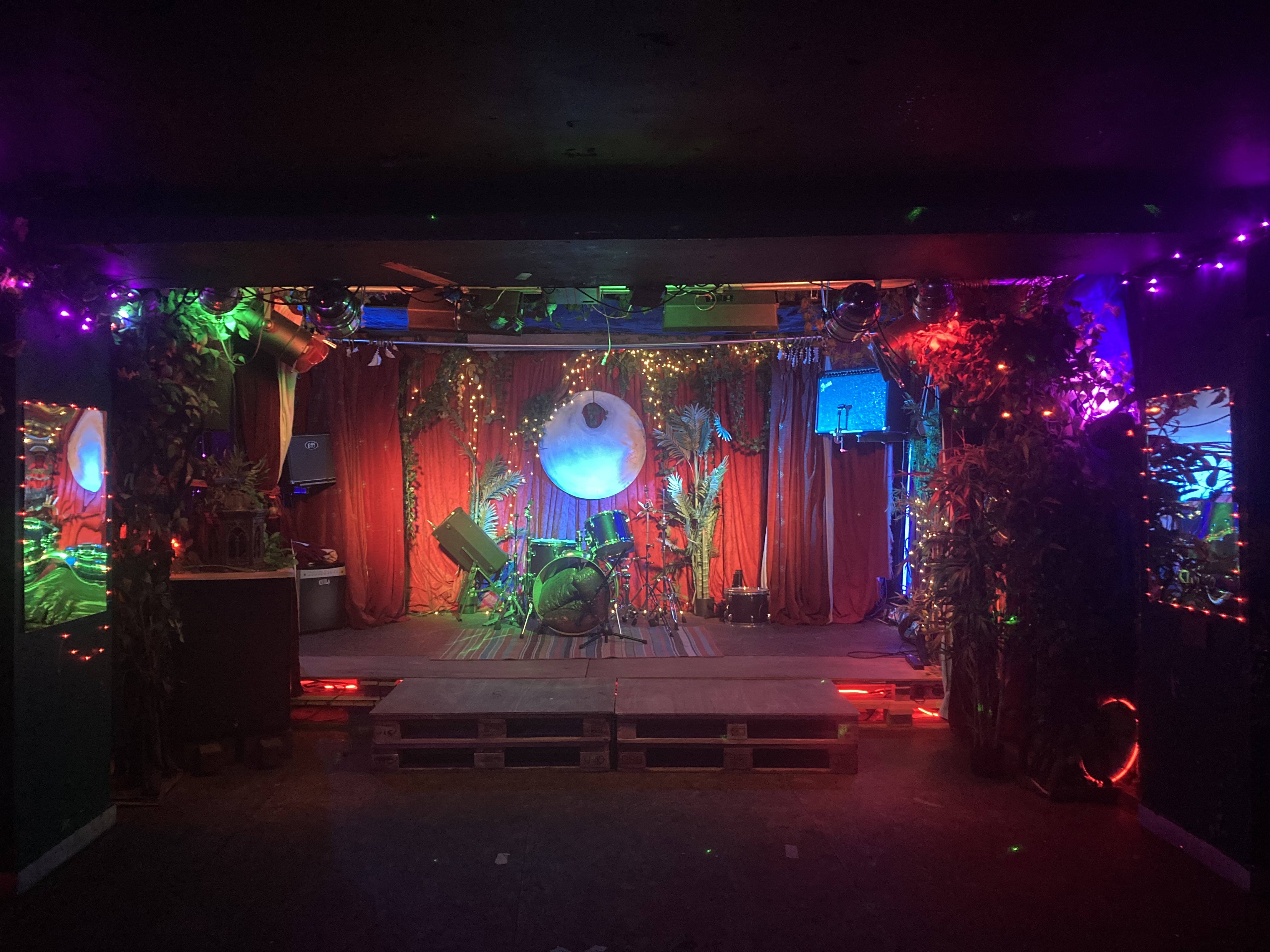 Vibrant event space with stage and colorful lighting for concerts and performances.