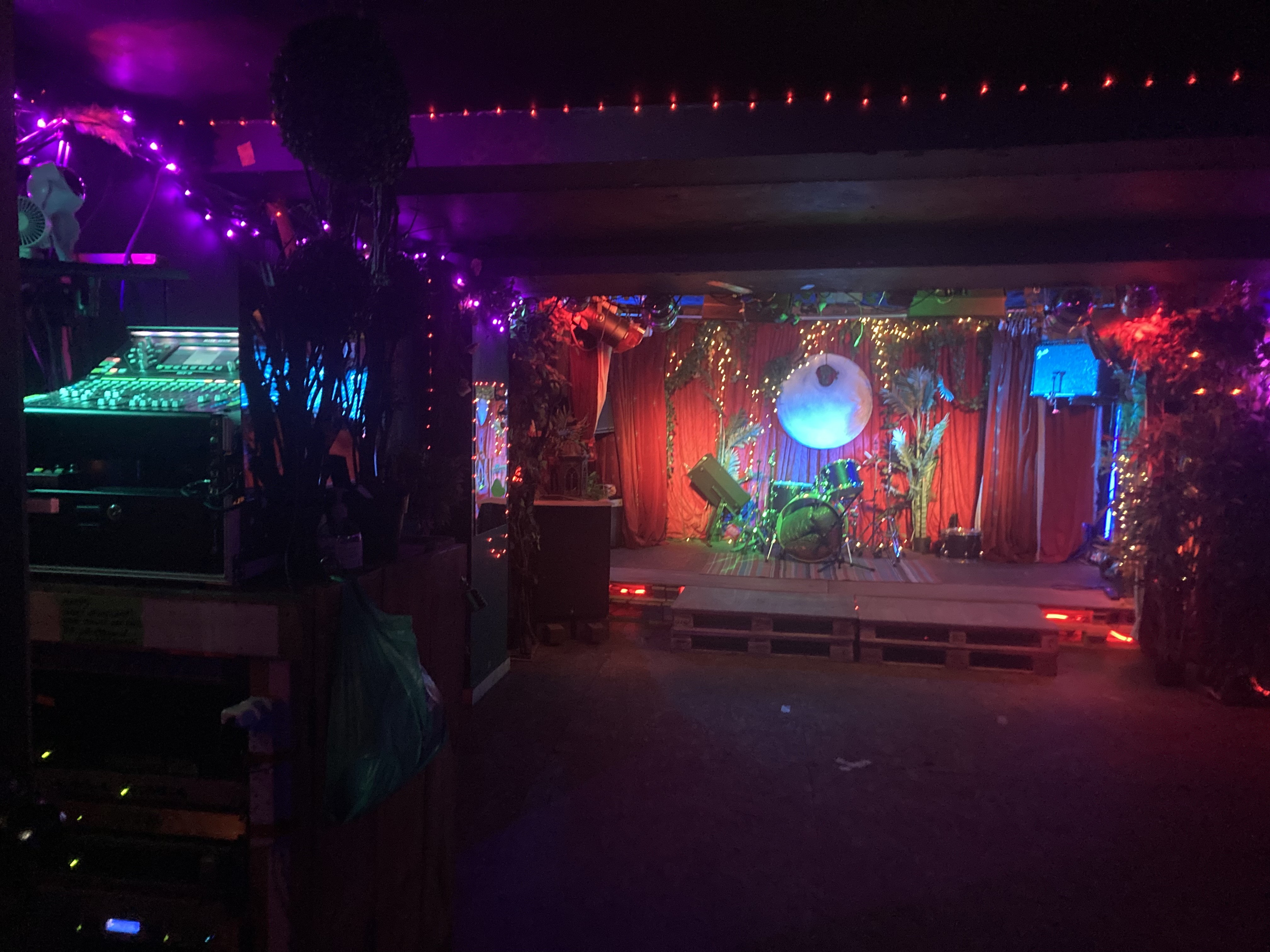 Vibrant event space with stage and colorful lights for music events and gatherings.