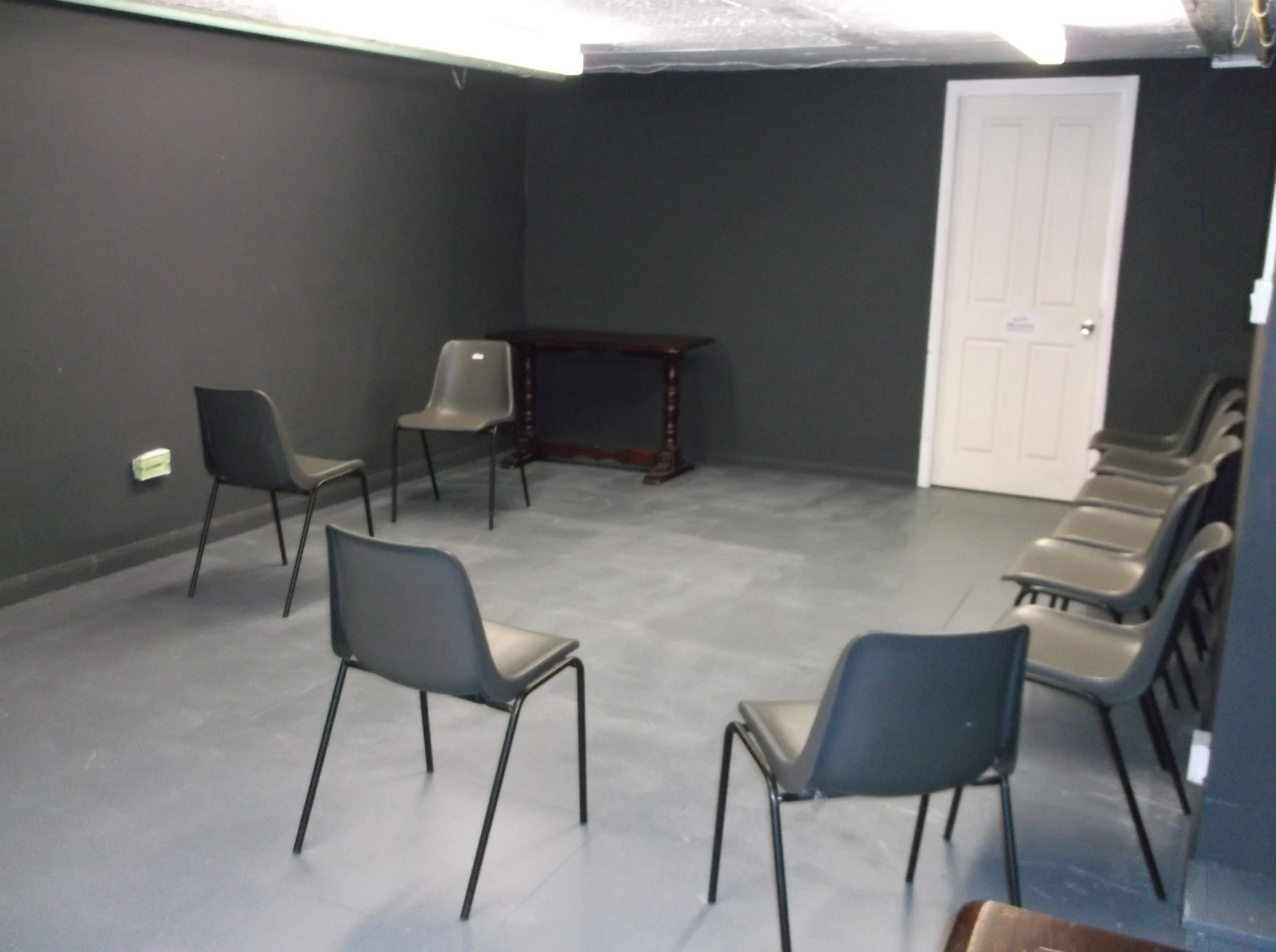 Minimalist meeting space in The Basement, Calder Theatre Bookshop for workshops and discussions.