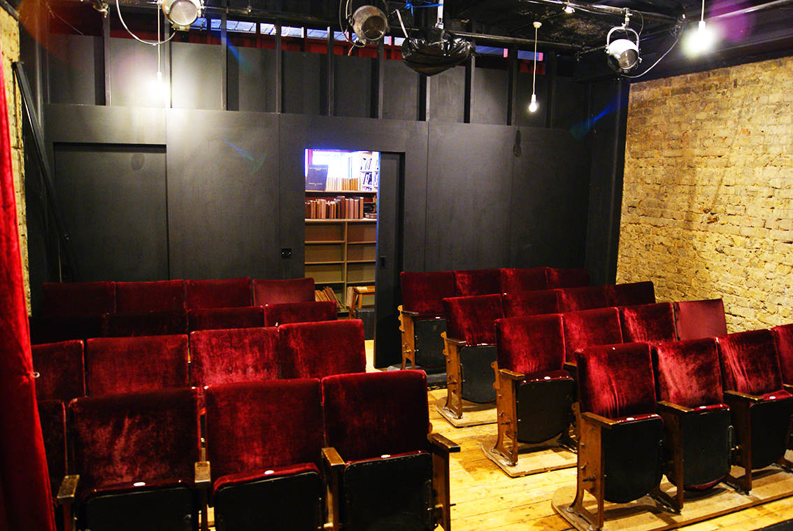 Intimate theater space with plush red seating, ideal for performances and presentations.