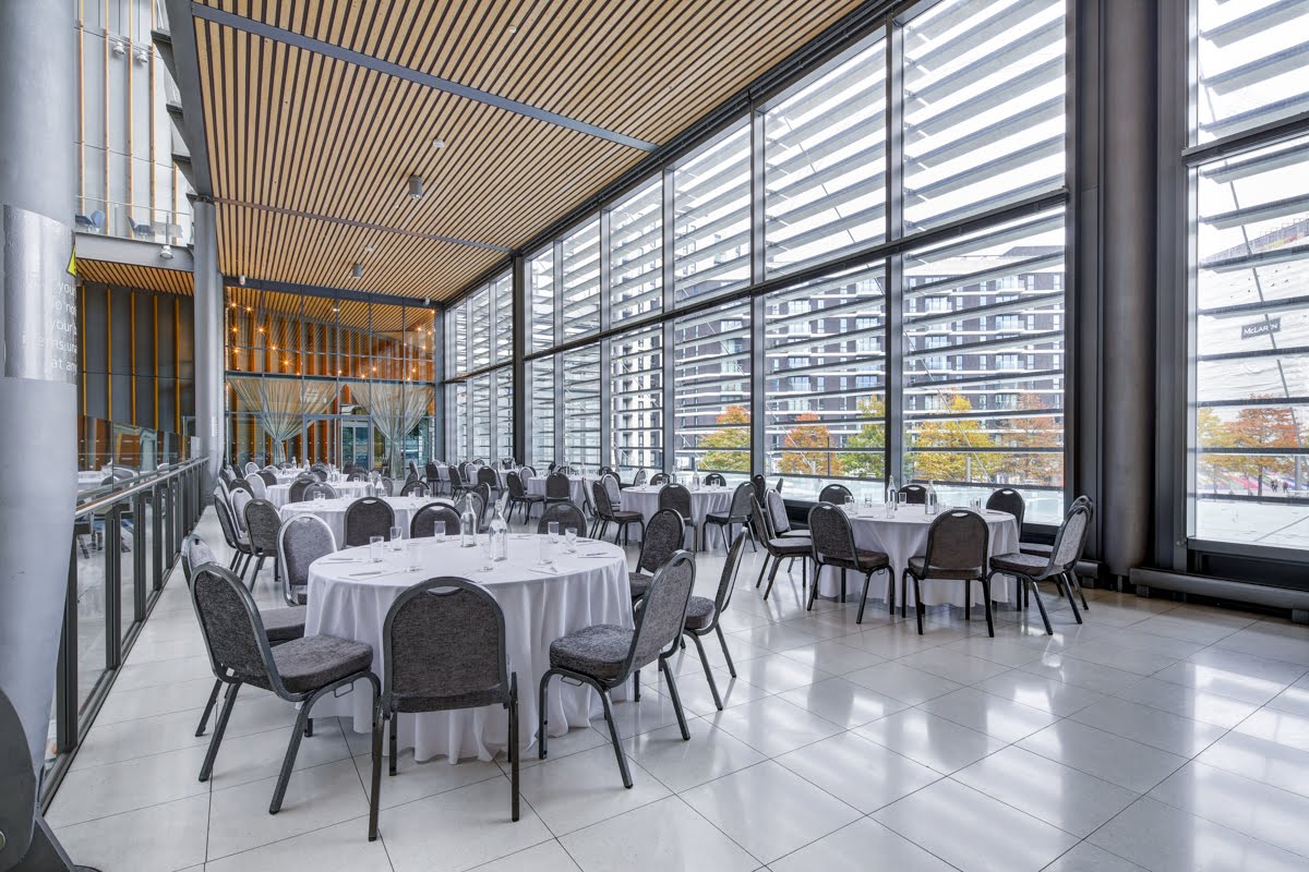 Modern event space in The Grand Hall, Wembley with elegant round tables for banquets.
