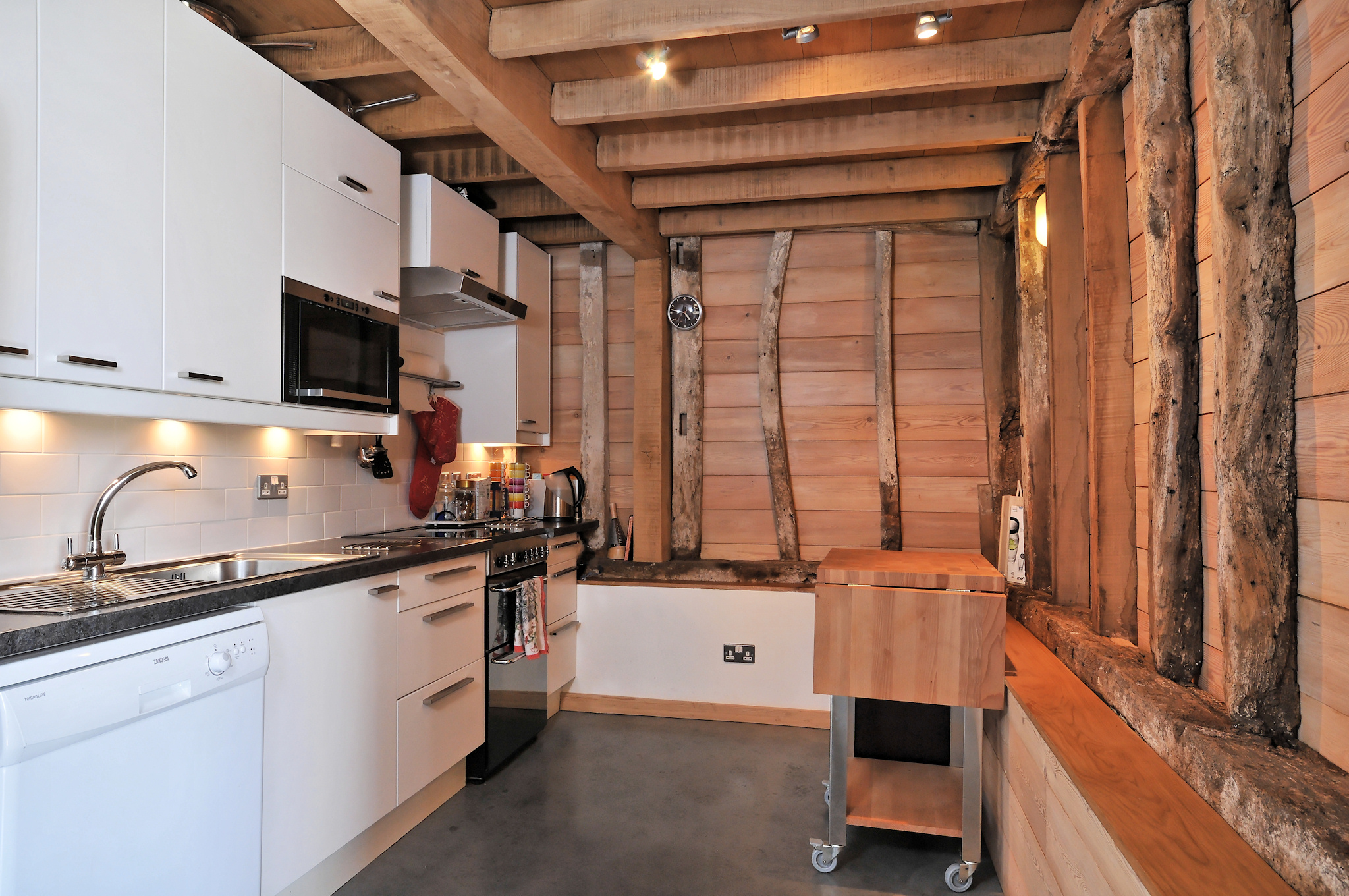 Modern kitchen with rustic beams, ideal for cooking classes and team-building events.