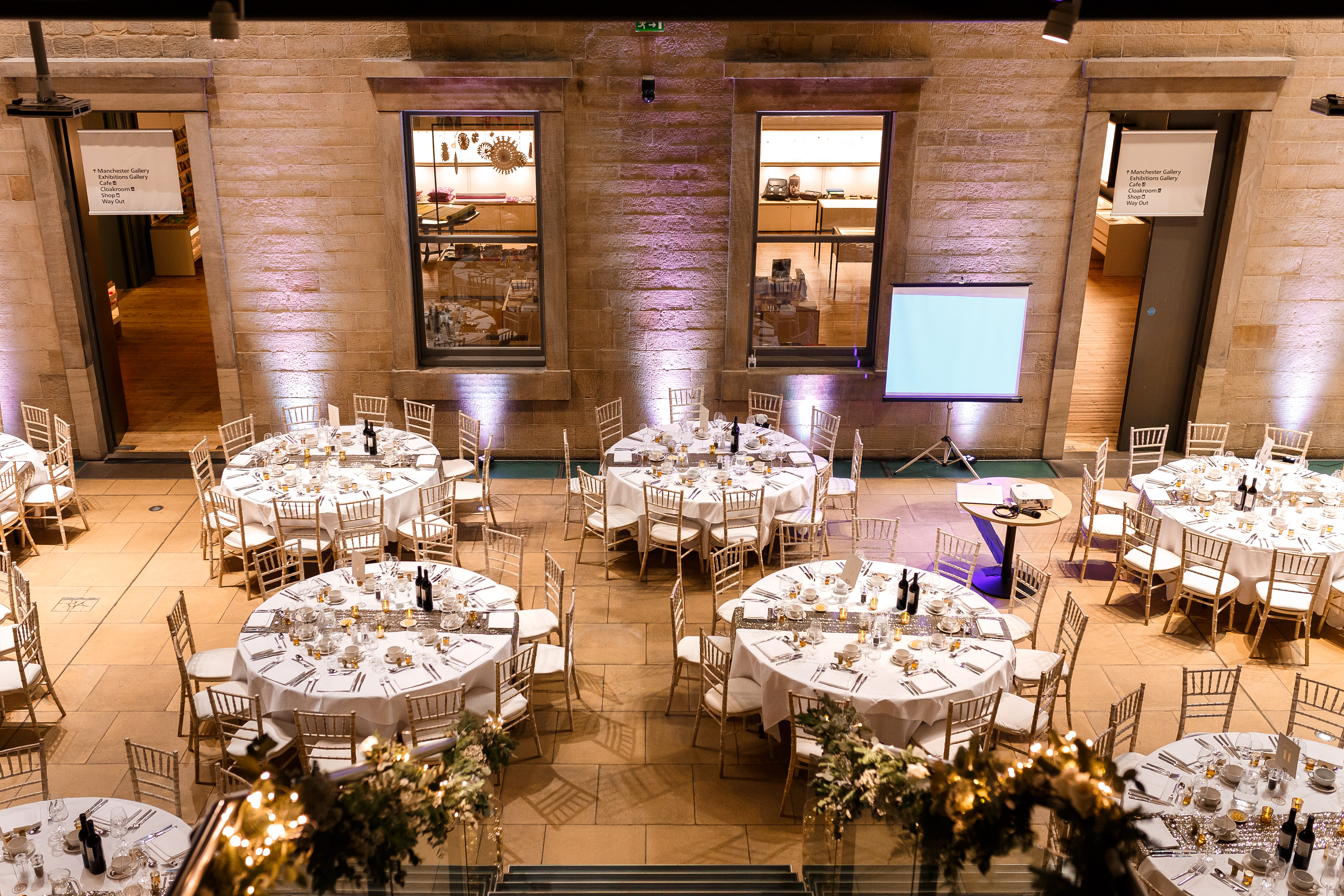 Atrium at Manchester Art Gallery, elegant wedding venue with round tables and soft lighting.