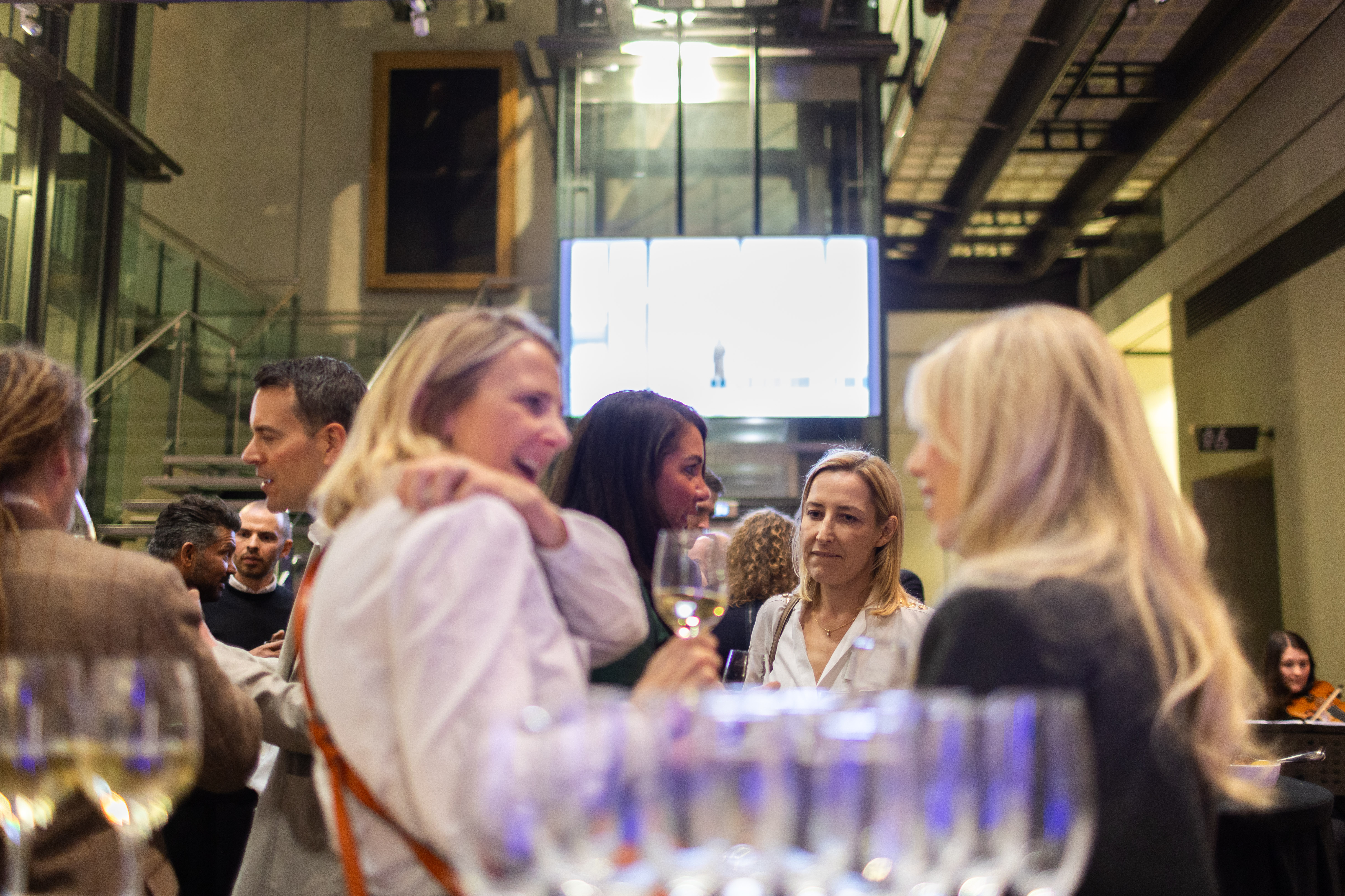 Atrium Manchester Art Gallery networking event with sparkling wine and modern ambiance.