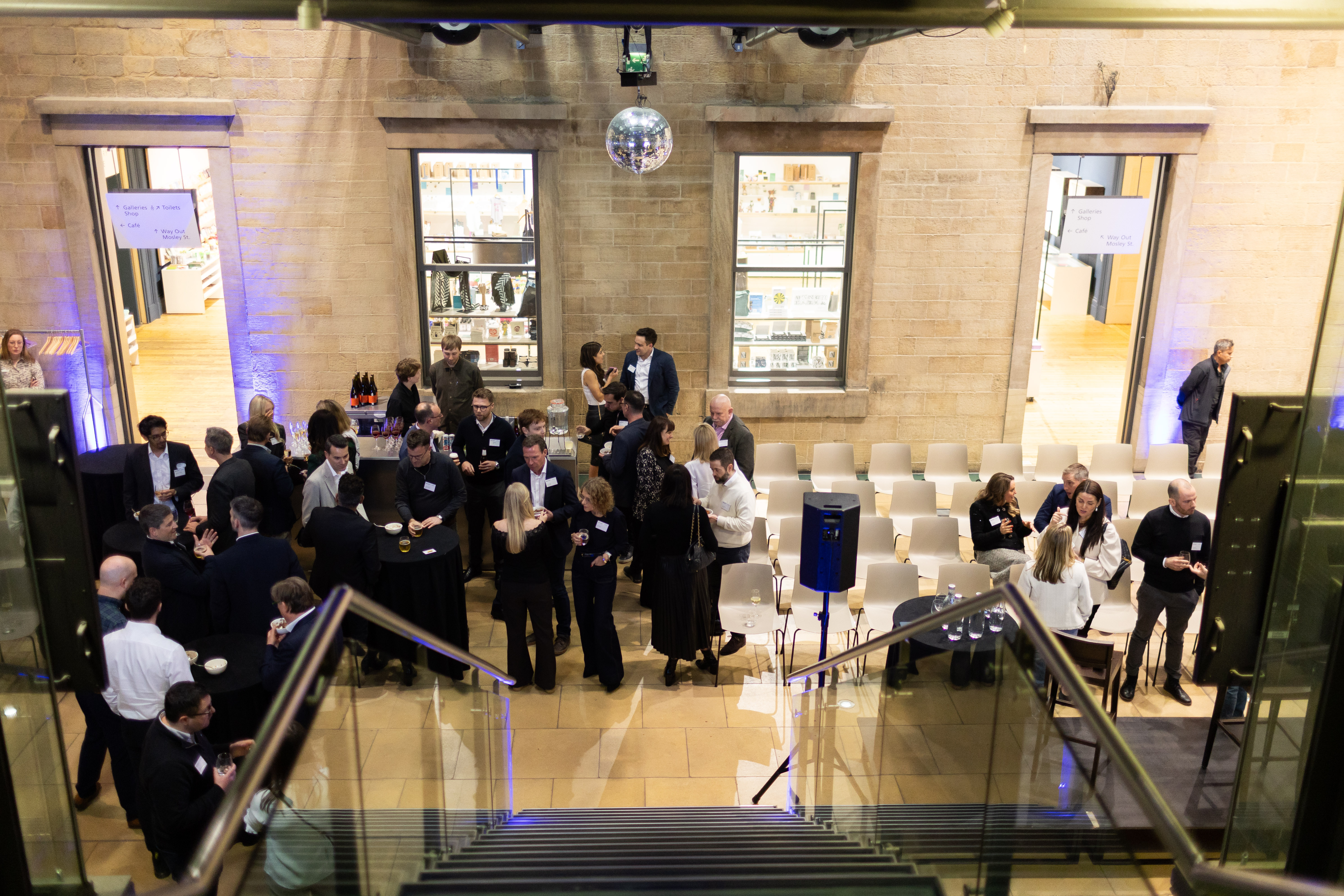 Atrium at Manchester Art Gallery during a networking event with guests and soft lighting.