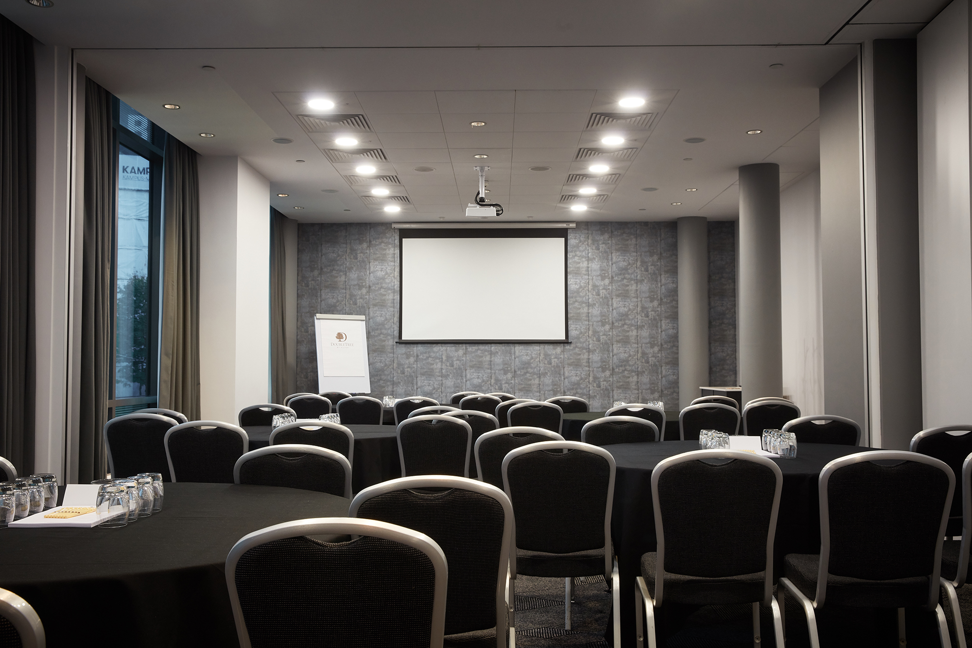 Meeting room with round tables at DoubleTree by Hilton Manchester for corporate events.