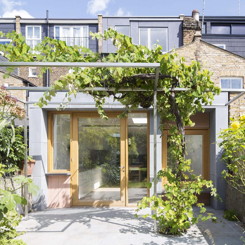 Charming modern front garden with glass doors, perfect for gatherings and brainstorming.