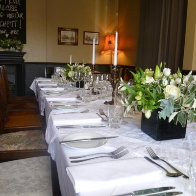 Elegant dining table with floral arrangements for intimate events in The Vine's front garden.