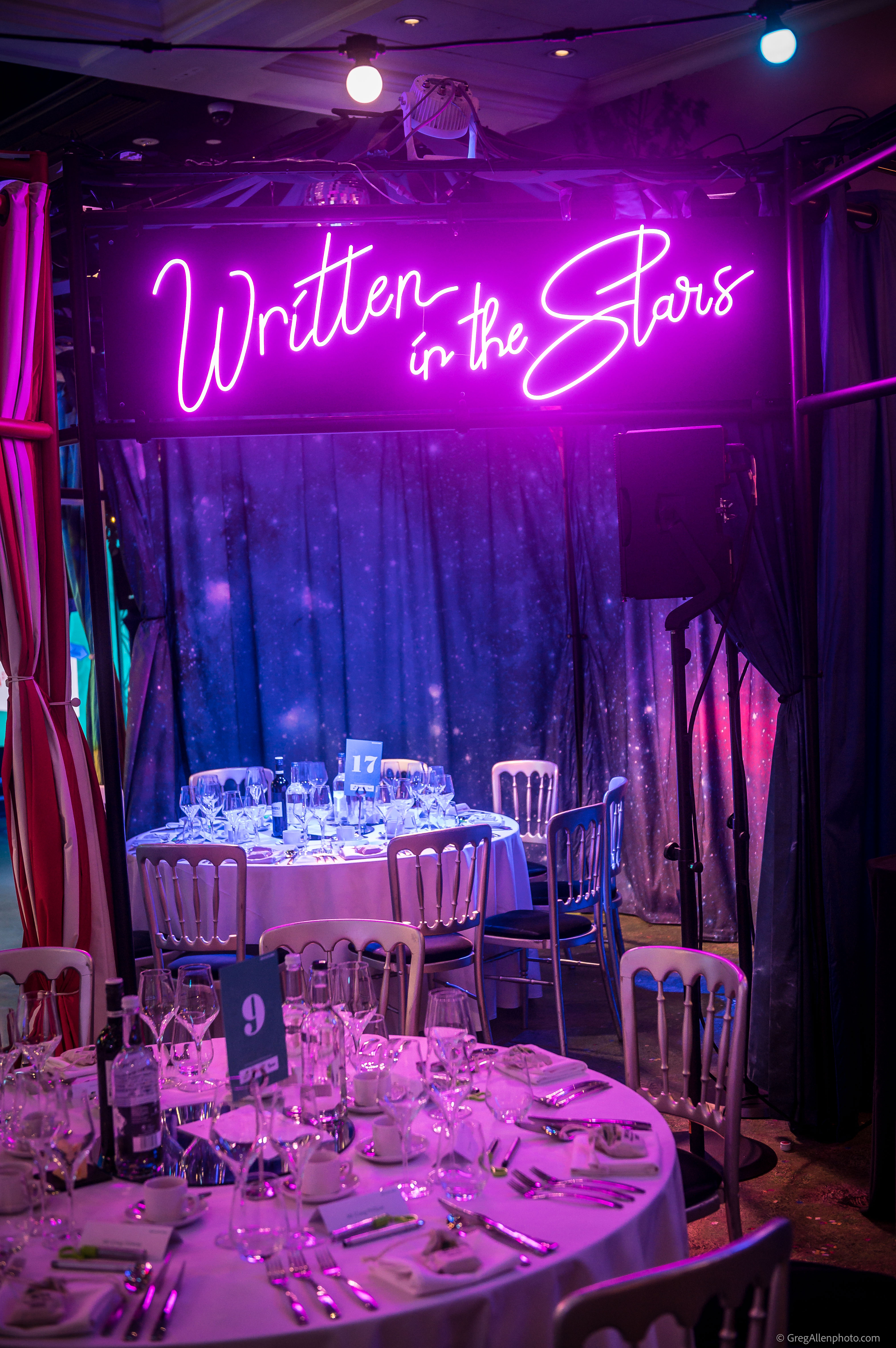 Round table under vibrant lighting at Madame Tussauds for gala dinner event.