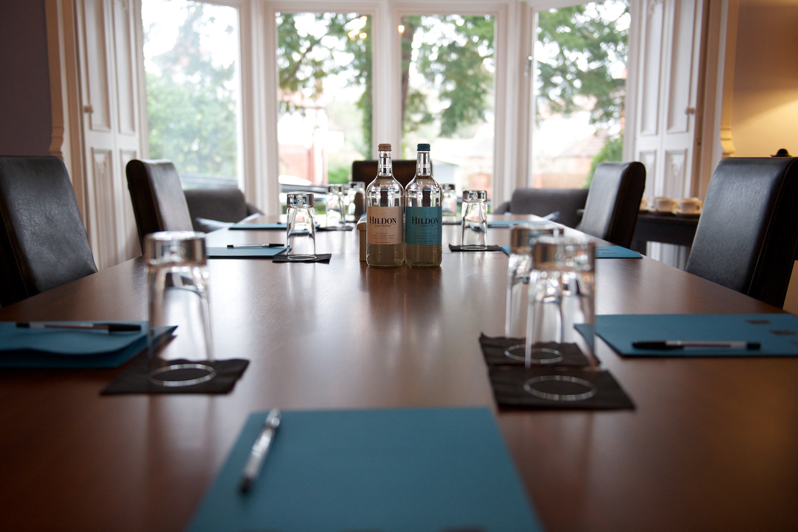 Boardroom at Didsbury House Hotel with polished table, ideal for meetings and brainstorming.