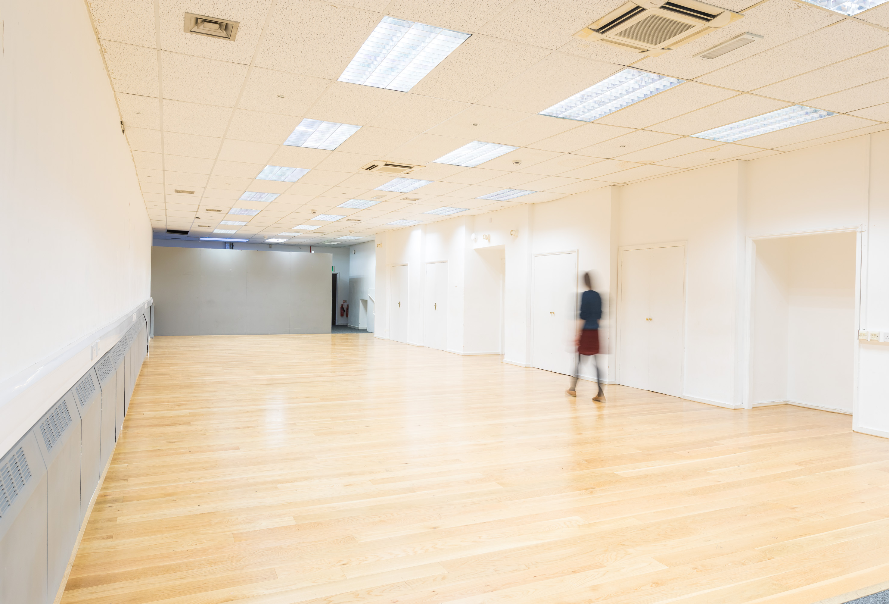 Spacious event space at Dominion Theatre with hardwood floor, ideal for networking events.