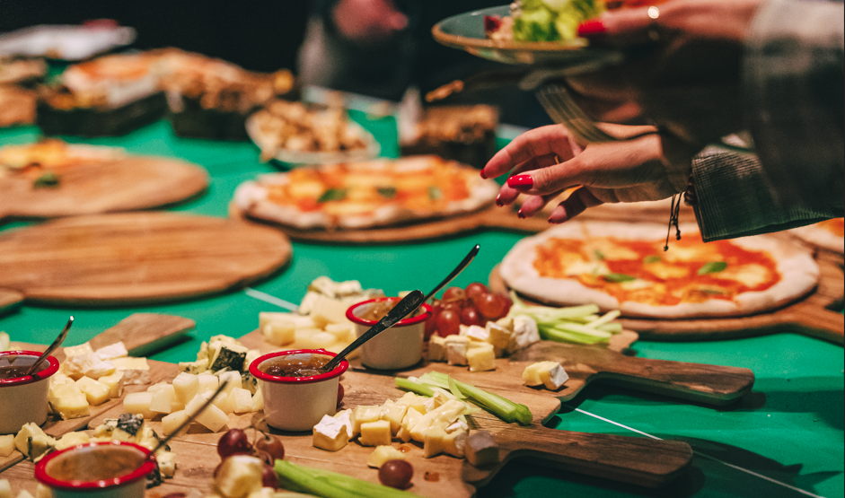 Vibrant buffet setup with pizzas and cheese for casual networking event at Bounce Farringdon.