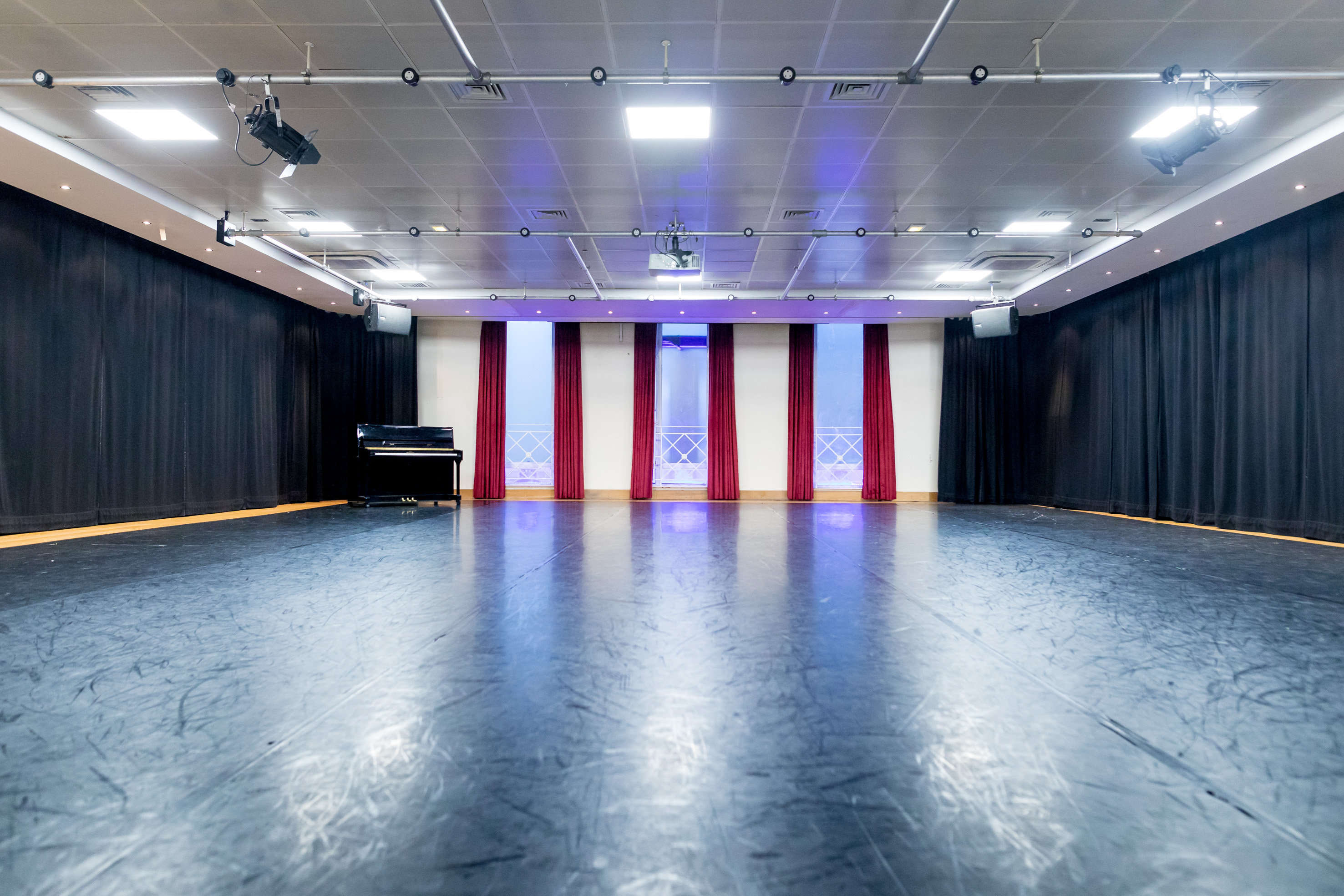 Versatile event space at Dominion Theatre with polished black floor, ideal for conferences.