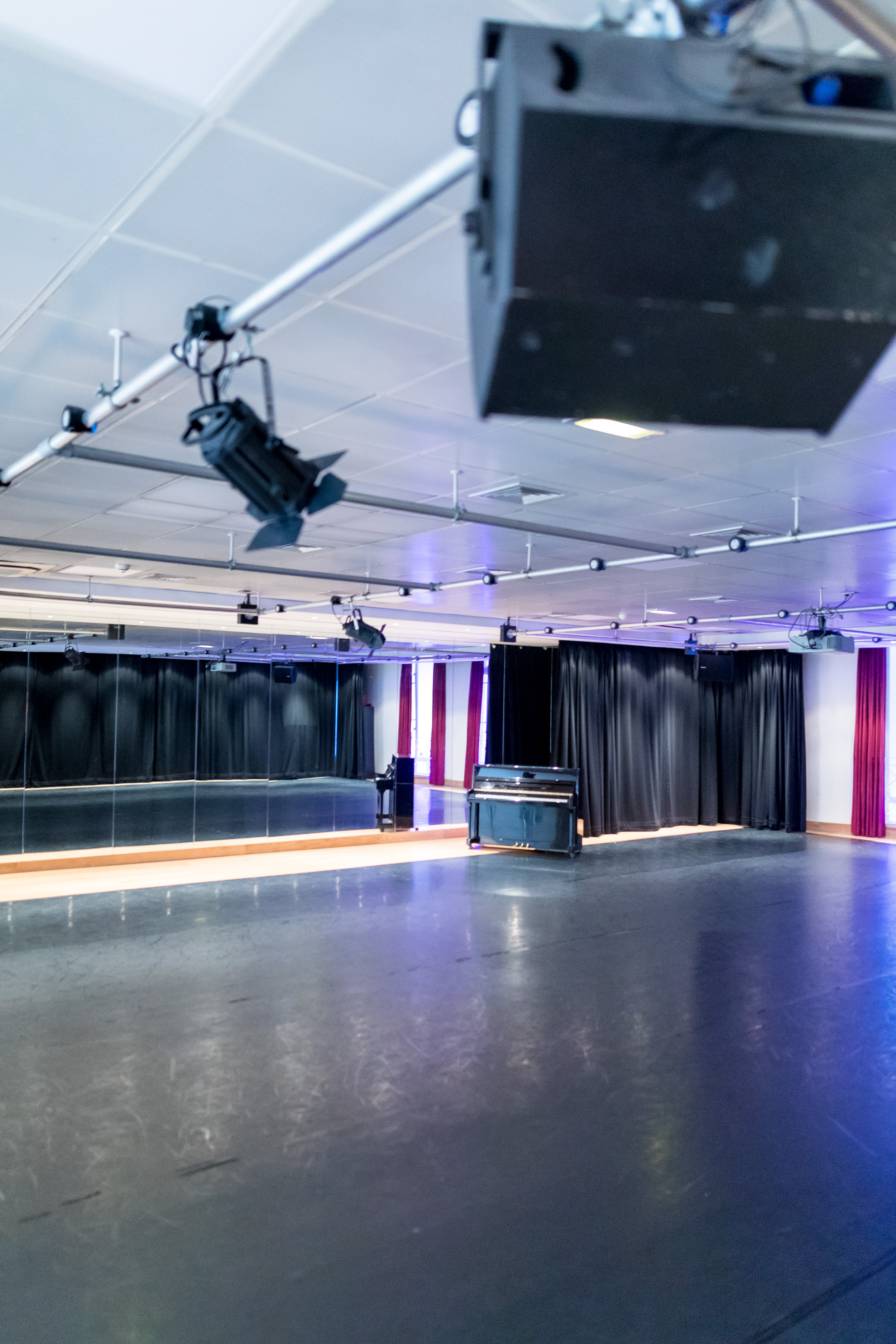 Versatile event space at Dominion Theatre with polished floor and piano for workshops.