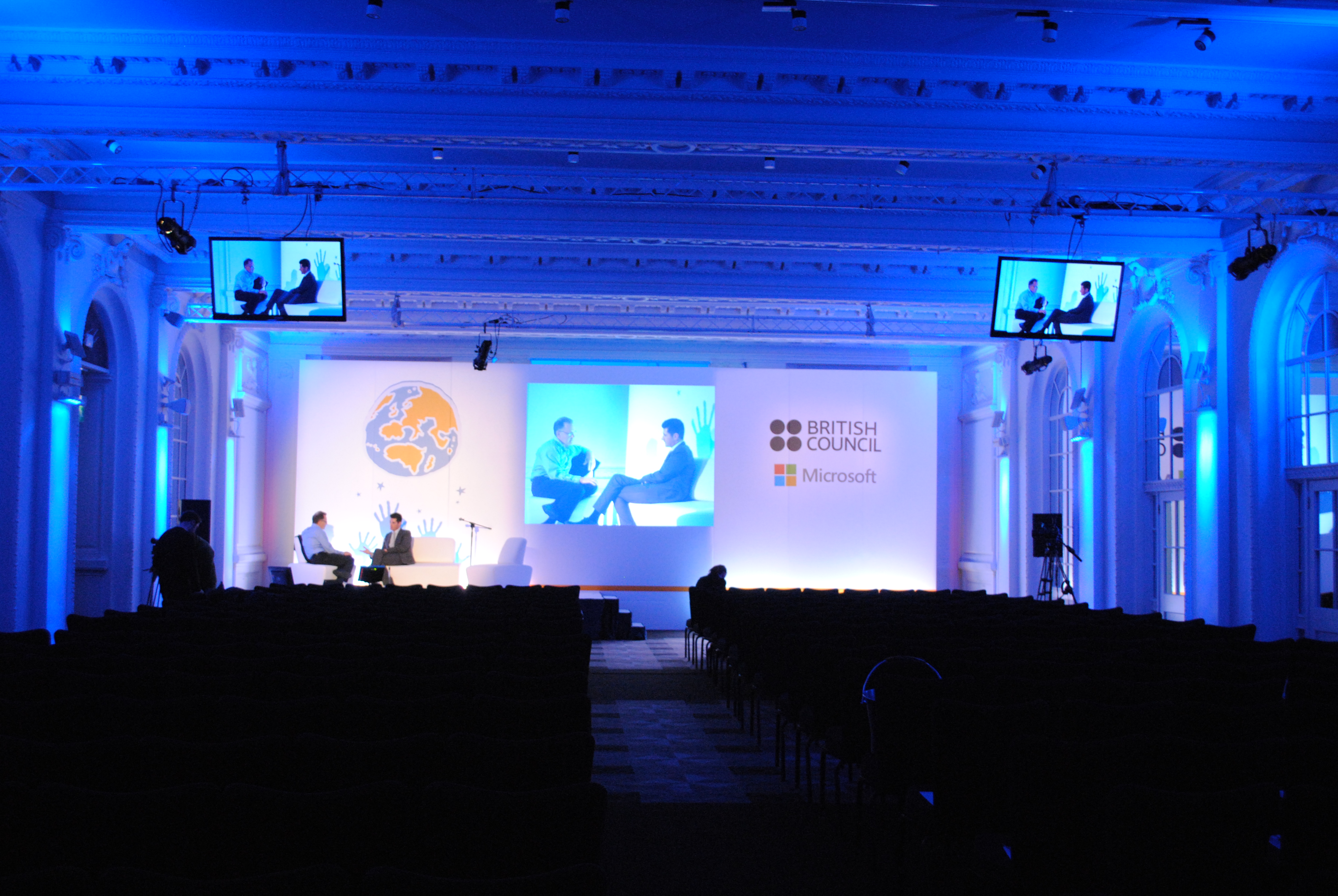 Old Billiard Room event space with blue lighting set for a panel discussion.