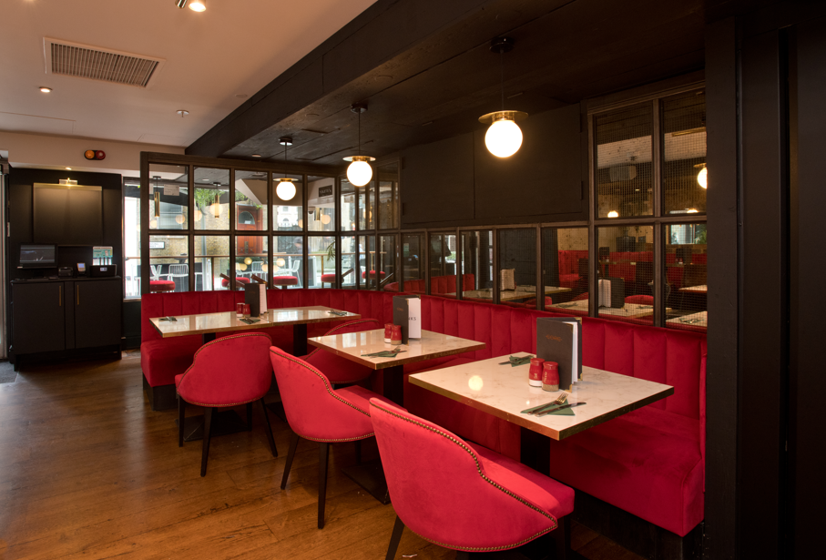 Stylish dining area with plush red seating at Top Bar, perfect for networking events.