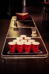 Casual social event setup with beer pong table and red cups for networking fun.