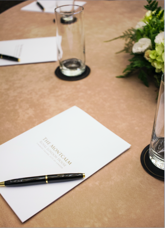 Royal London Suite meeting setup with elegant floral arrangement and branded materials.
