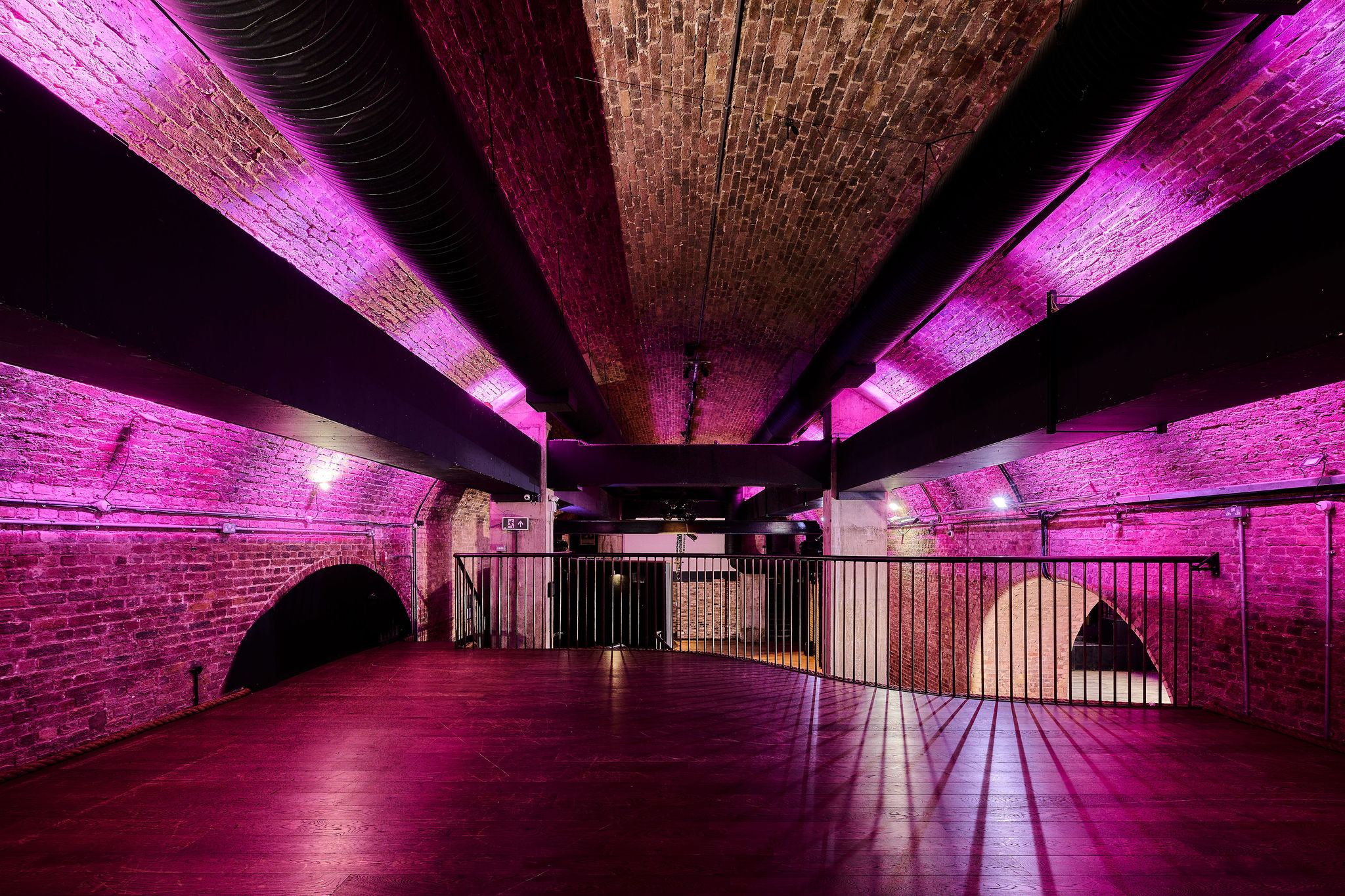 Whole Venue at The Steel Yard with exposed brick walls and purple lighting for events.