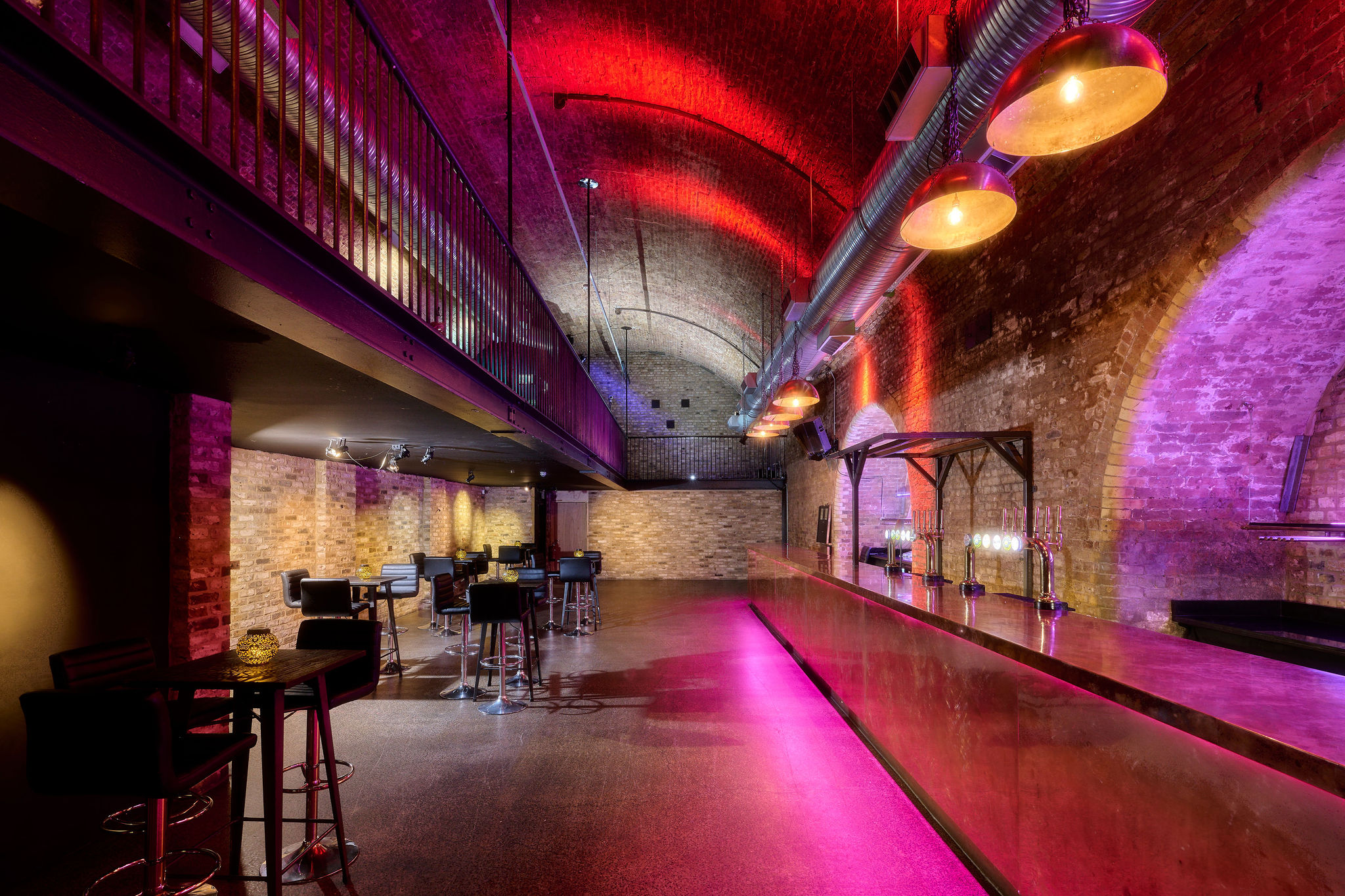 Stylish industrial event space at The Steel Yard with exposed brick and dramatic lighting.