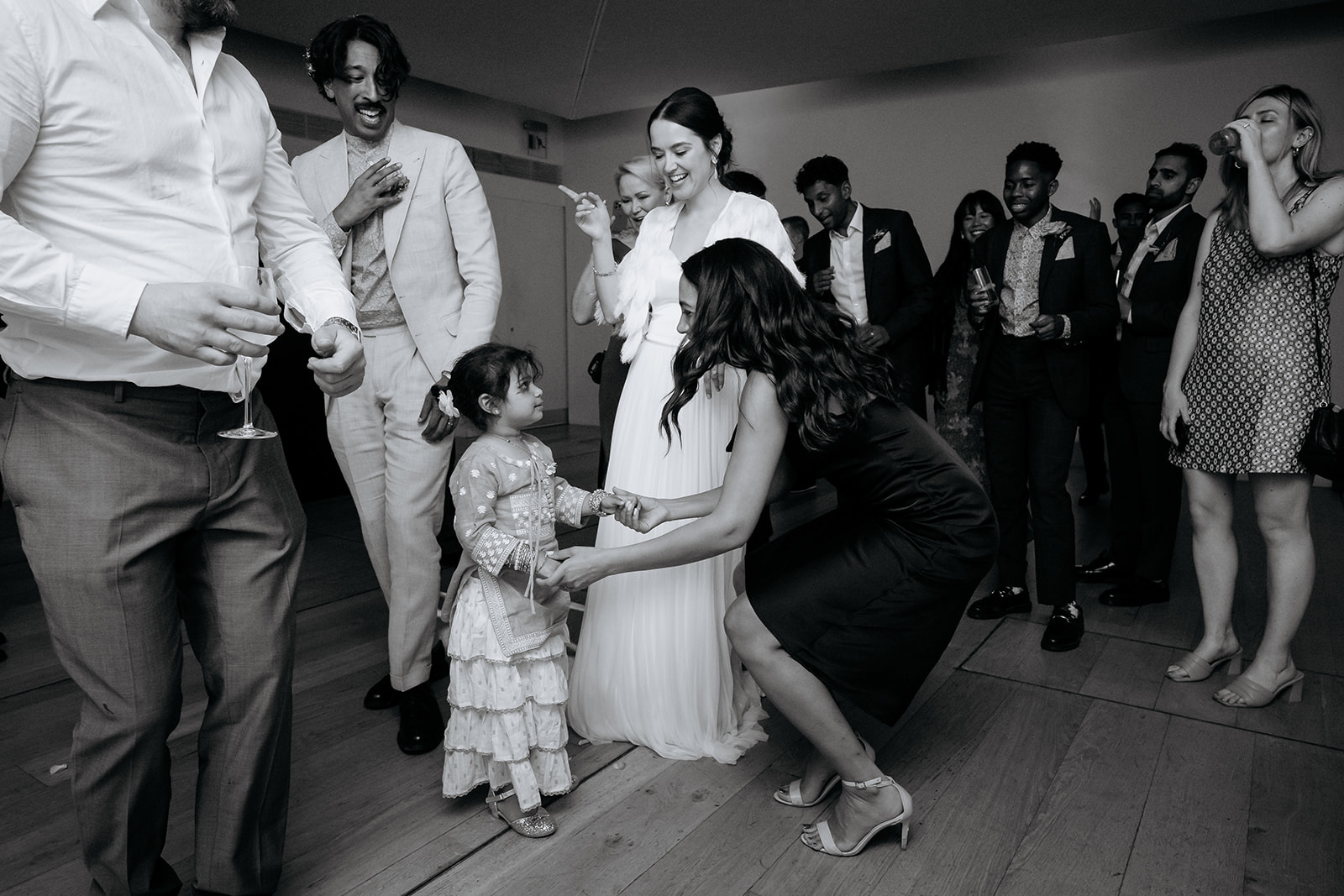Wedding celebration in The Linbury Room, bride interacting with guests, joyful atmosphere.